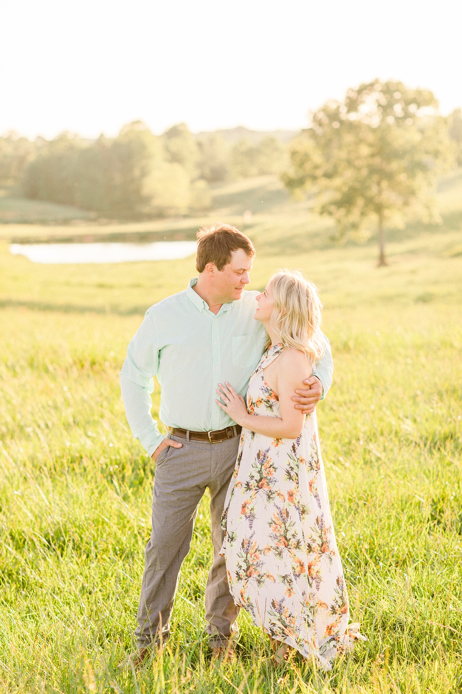 bride and groom hug in field during spring engagement photos