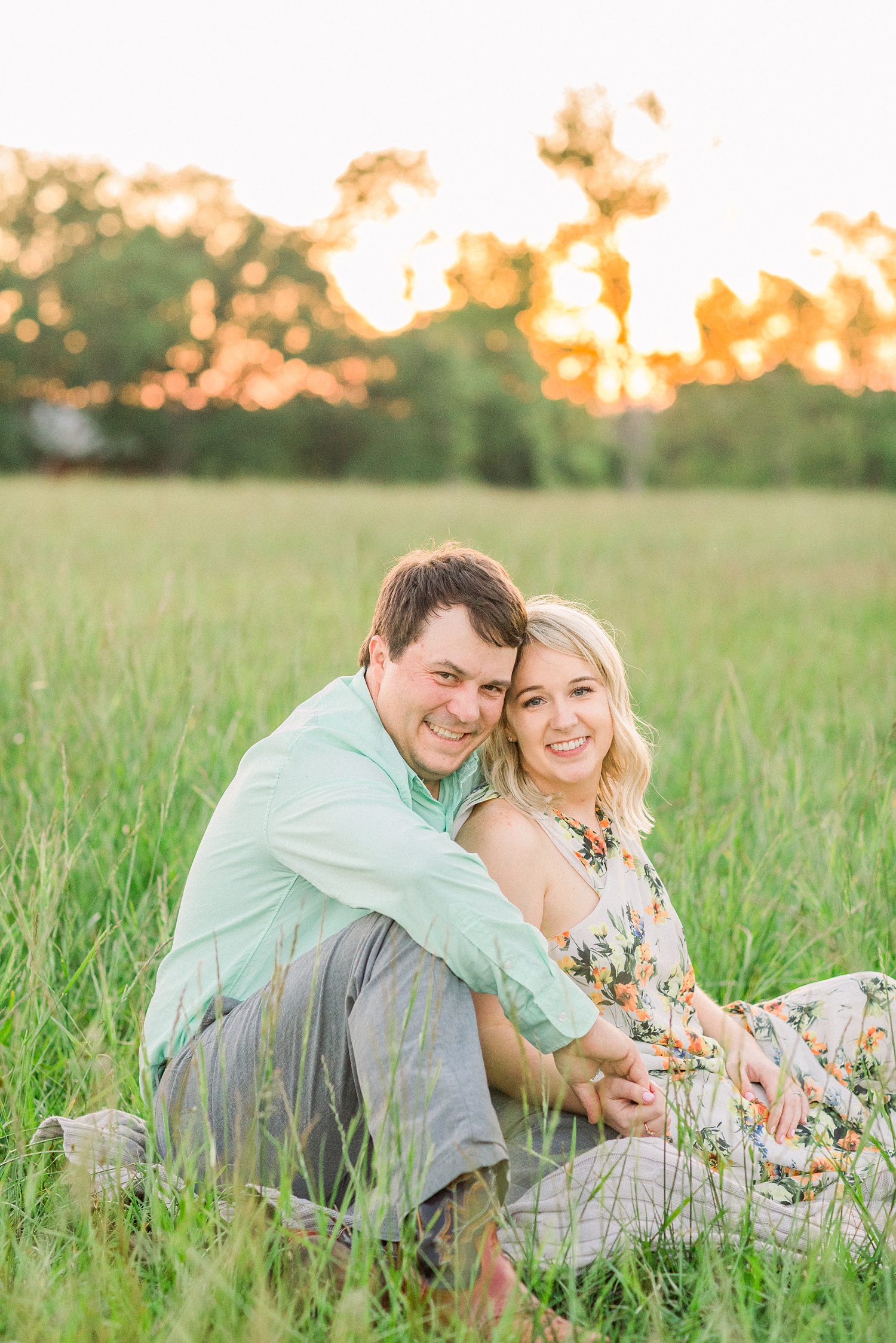 bride and groom sit on blanket in Alabama field