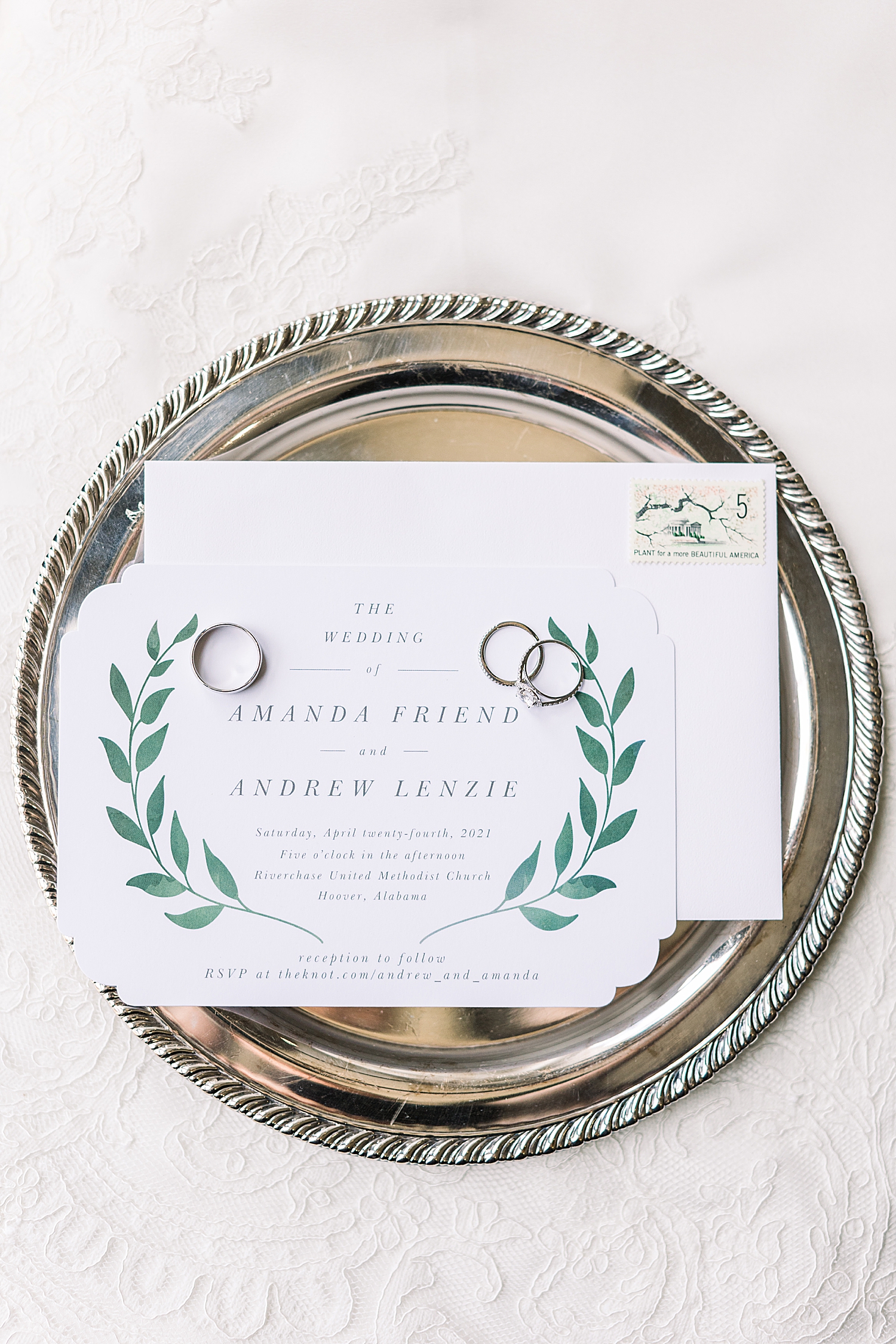 wedding invitation rests on silver tray
