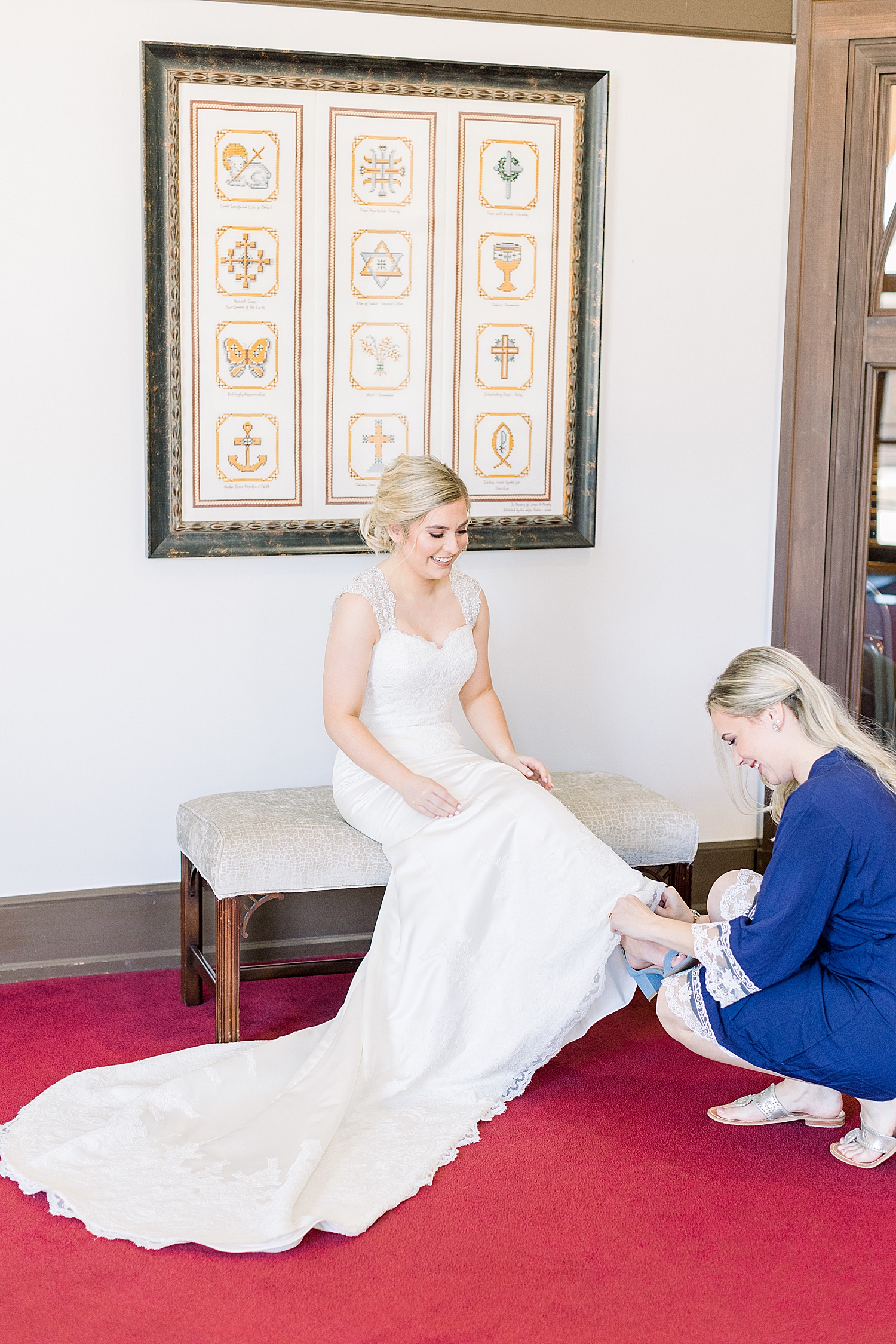 bridesmaid helps bride with shoes for wedding day