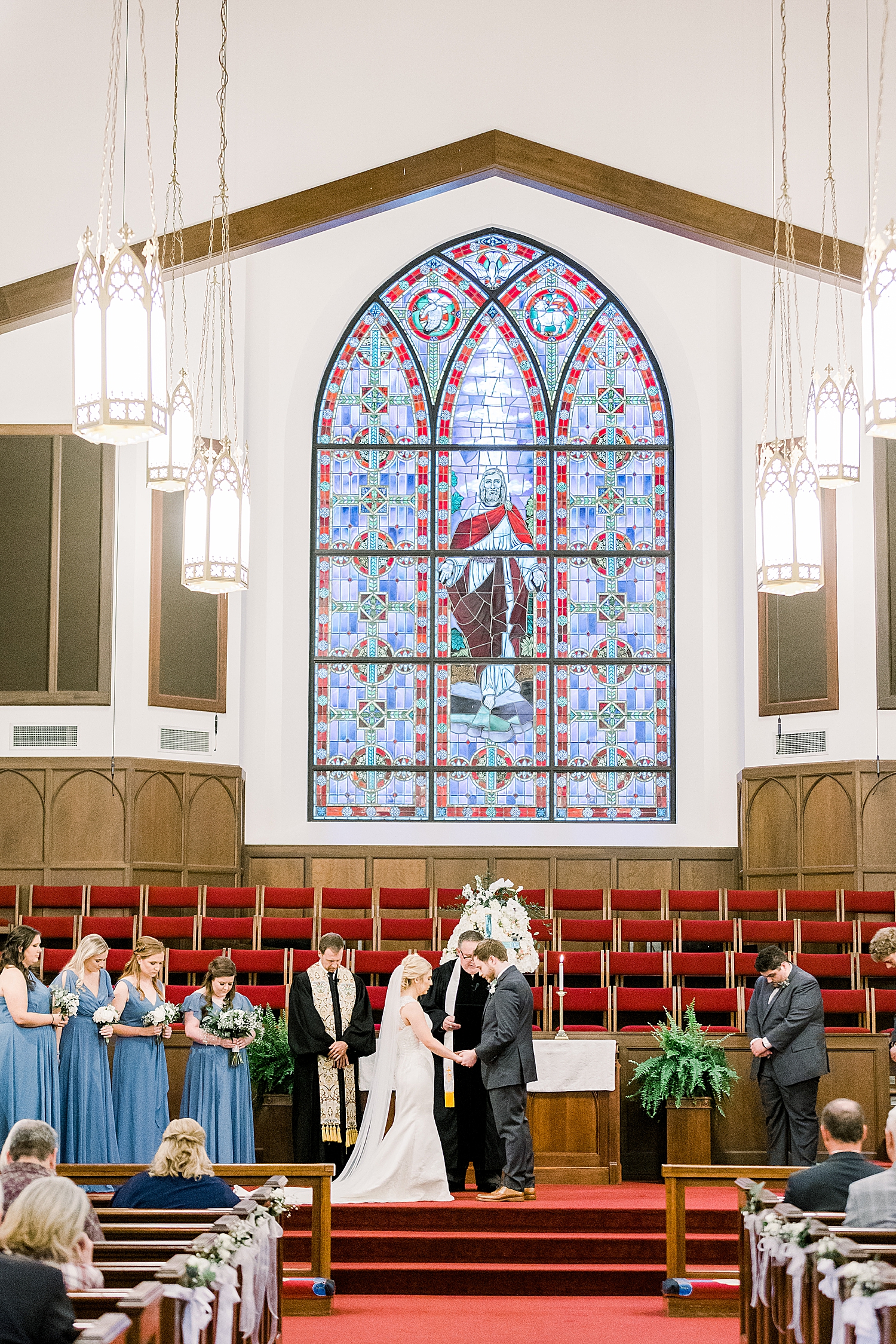bride and groom pose at alter during traditional church wedding