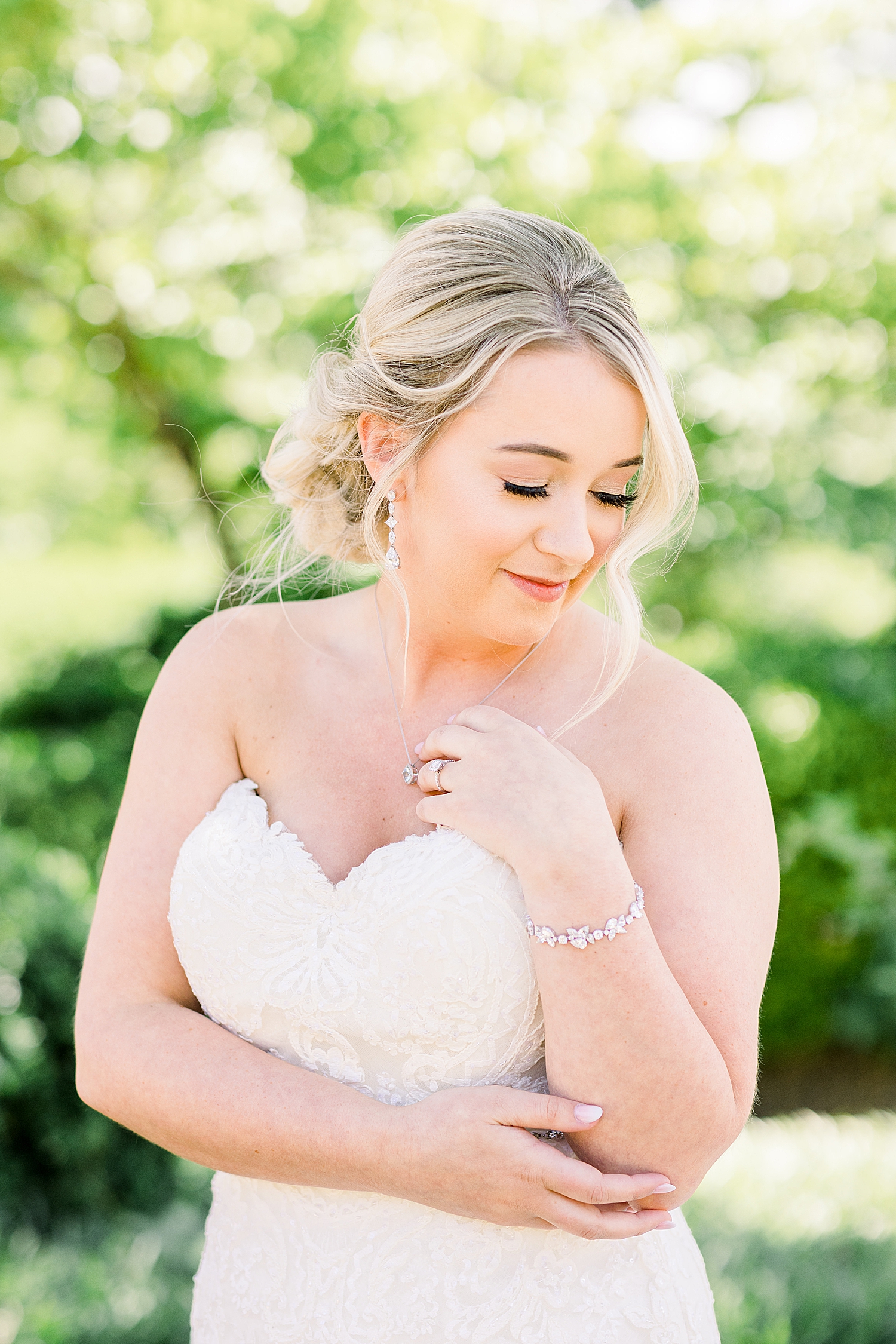 bride looks over shoulder holding tendril of hair