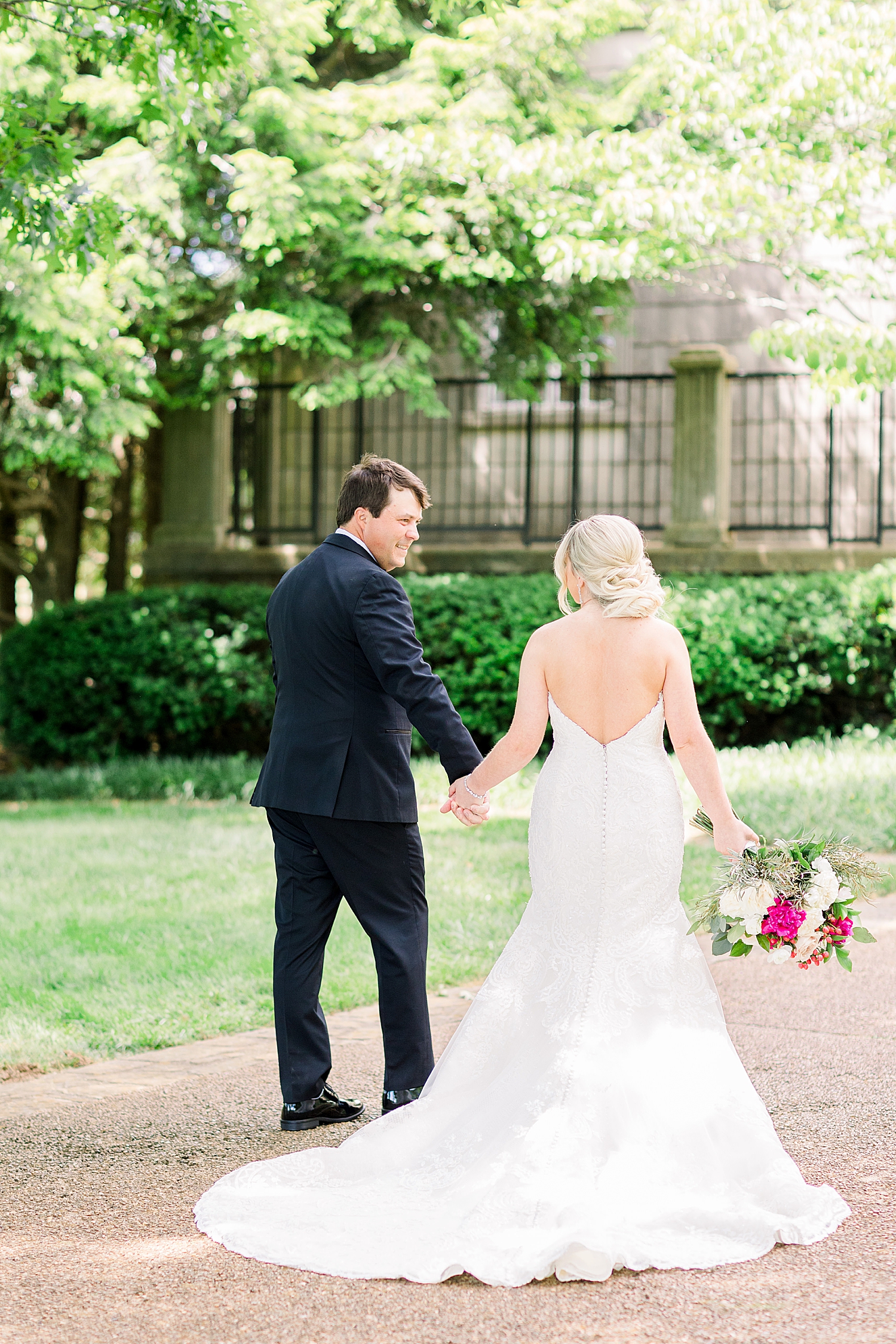 newlyweds hold hands walking through Alabama venue