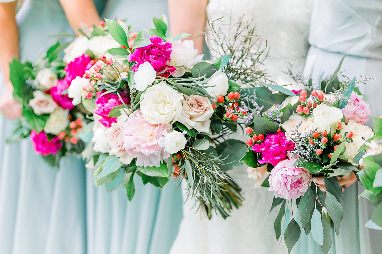 bride and bridesmaids hold pastel pink flowers