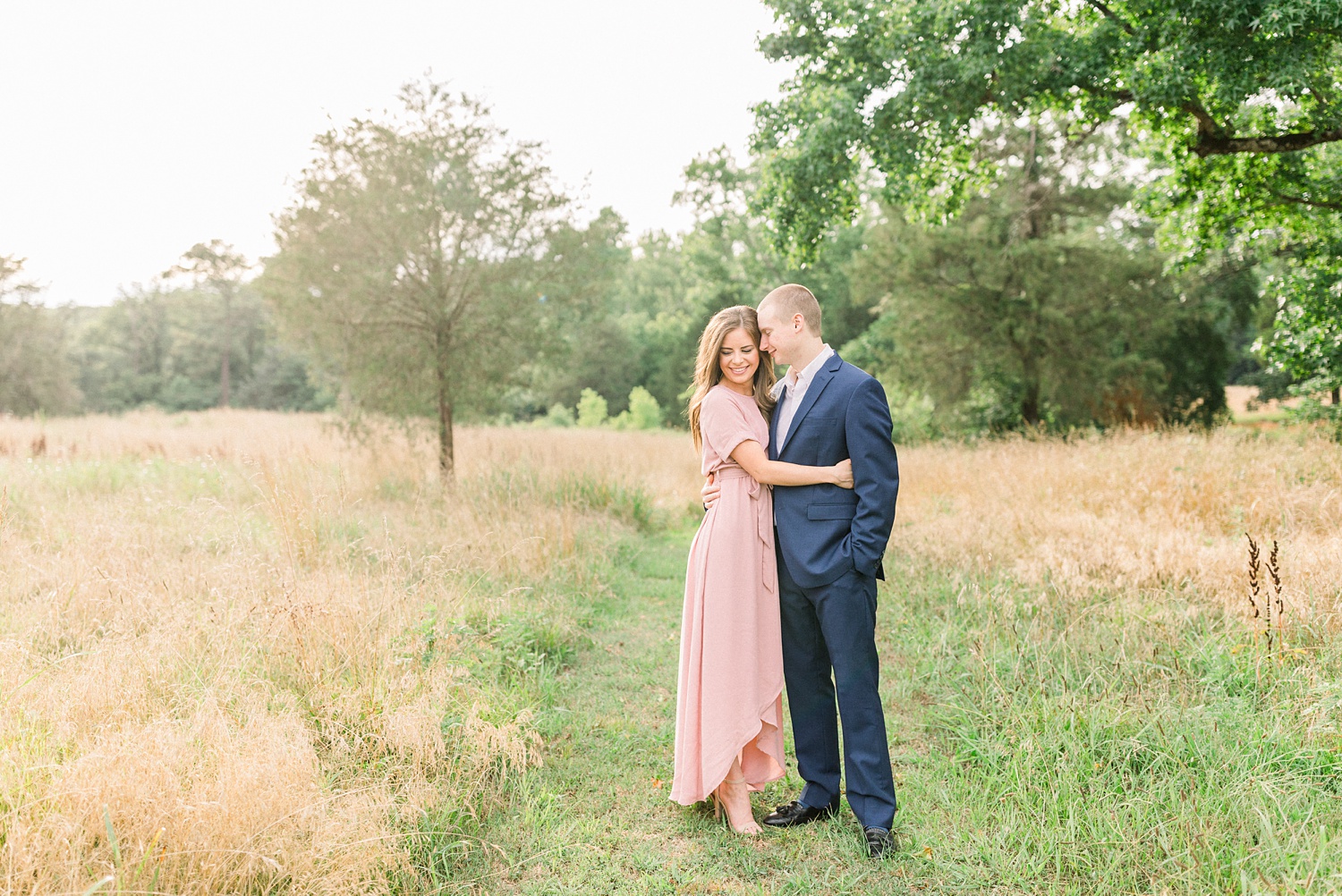 bride and groom stand together in field during Montevallo AL engagement session