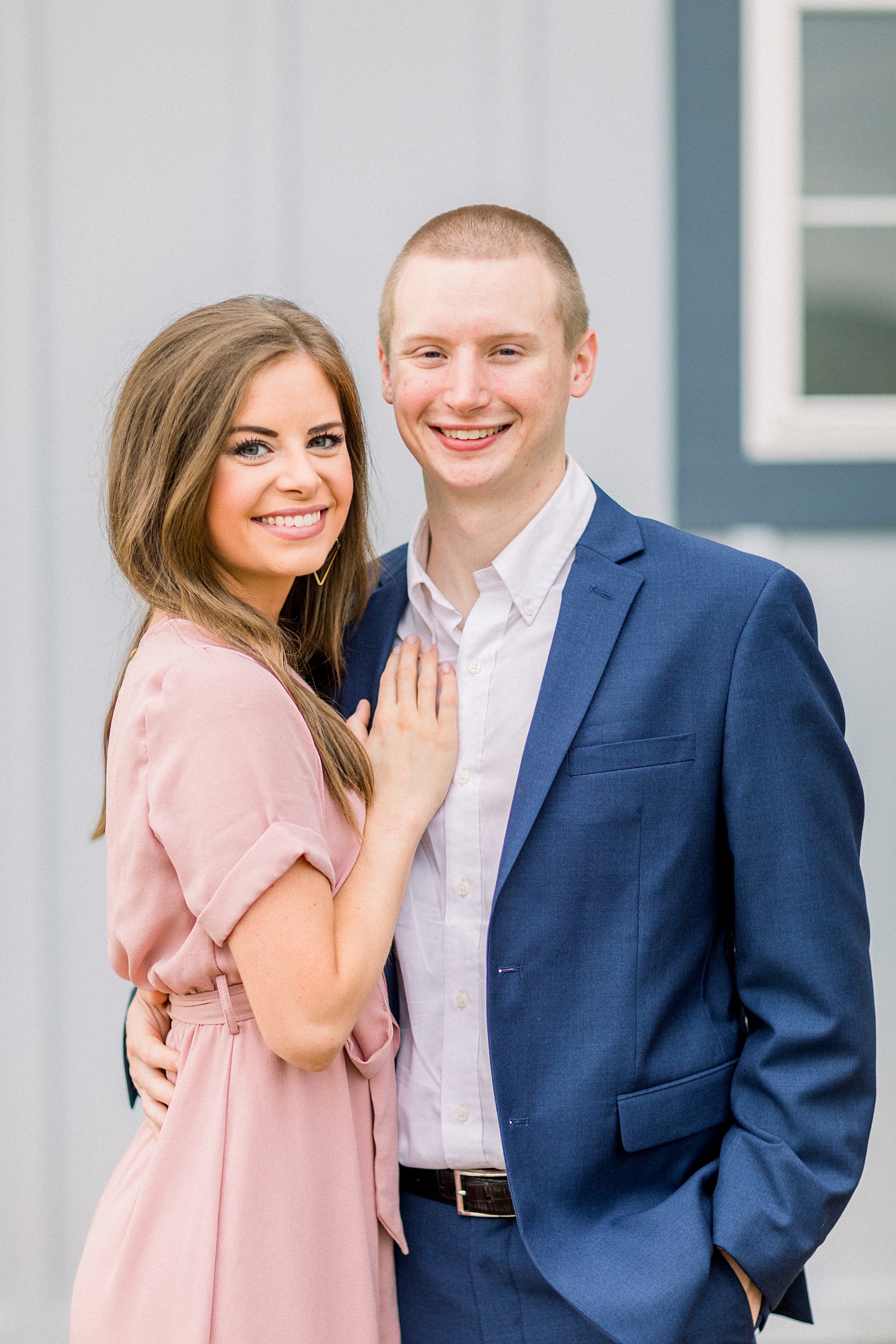 engaged couple poses by building in Montevallo AL