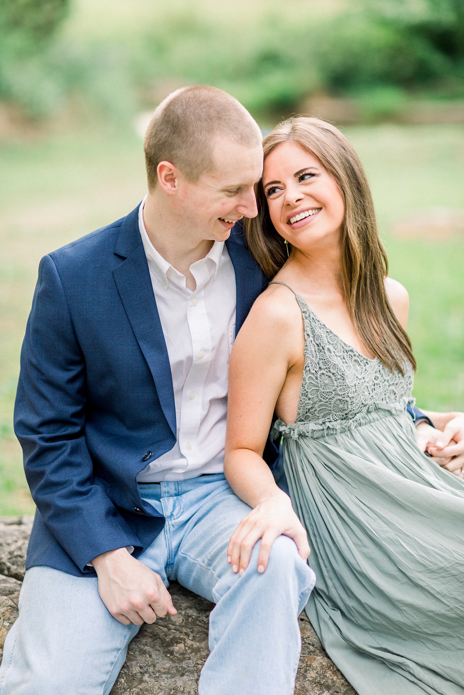 engaged couple sits together on rocks during Montevallo AL engagement session