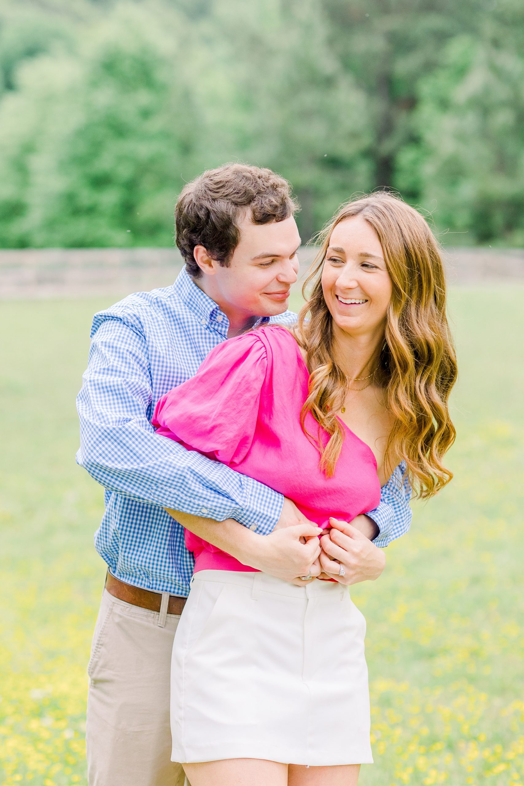 couple hugs in field during spring Birmingham AL engagement session