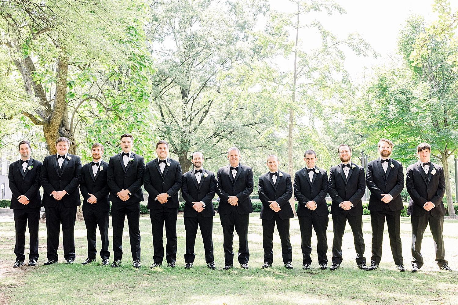 groom poses with groomsmen in classic black tuxes