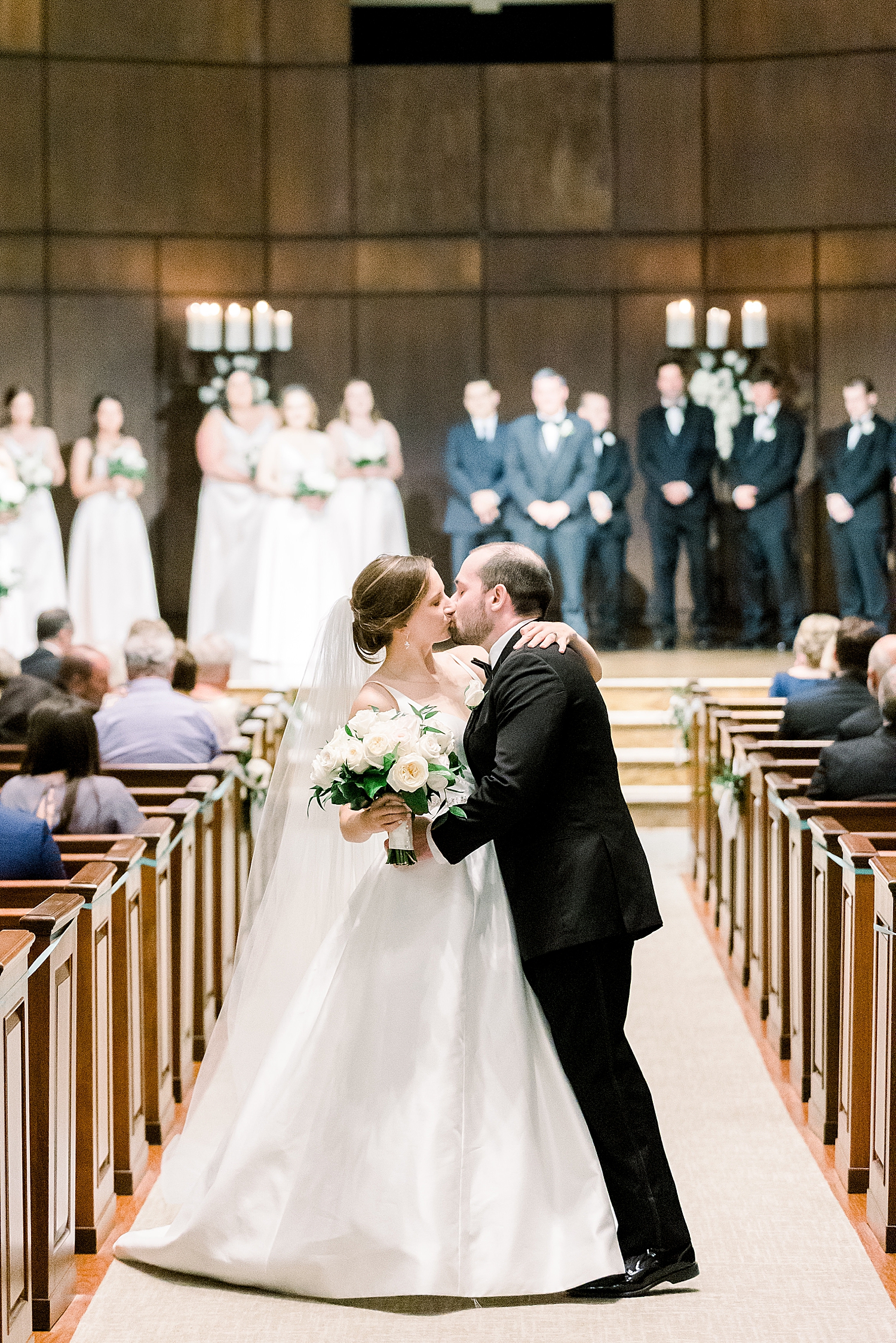 married couple kisses in aisle during traditional wedding ceremony at Mountain Brook Community Church