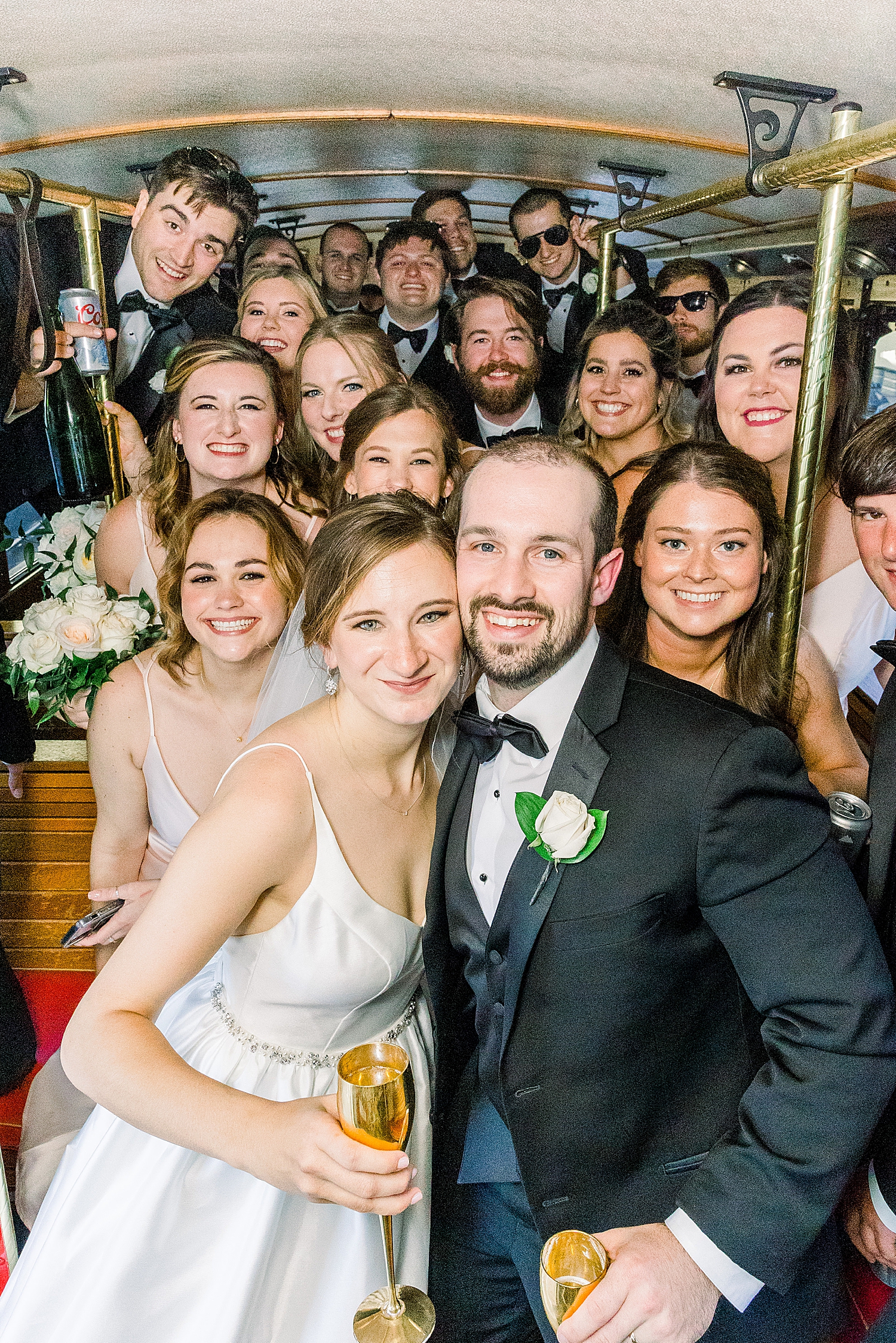 bride and groom pose with bridal party on trolley in Birmingham AL