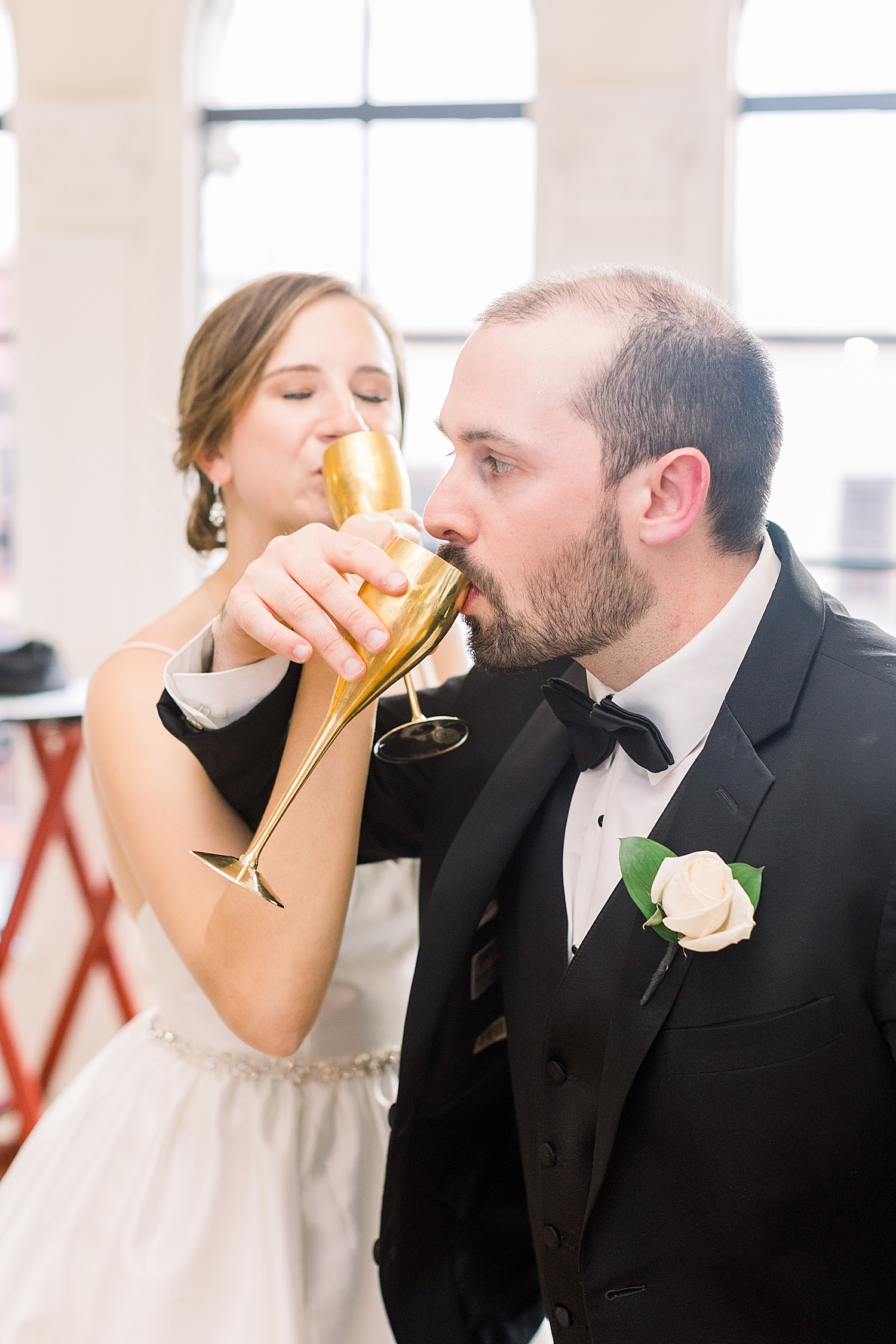 groom and bride toast with gold flutes