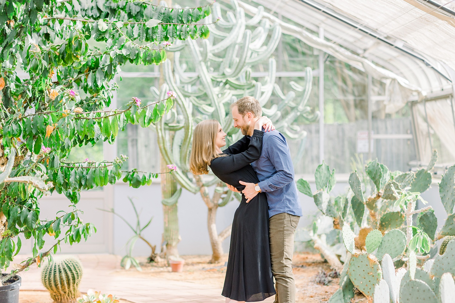 couple hugs in greenhouse during Birmingham Botanical Gardens engagement portraits