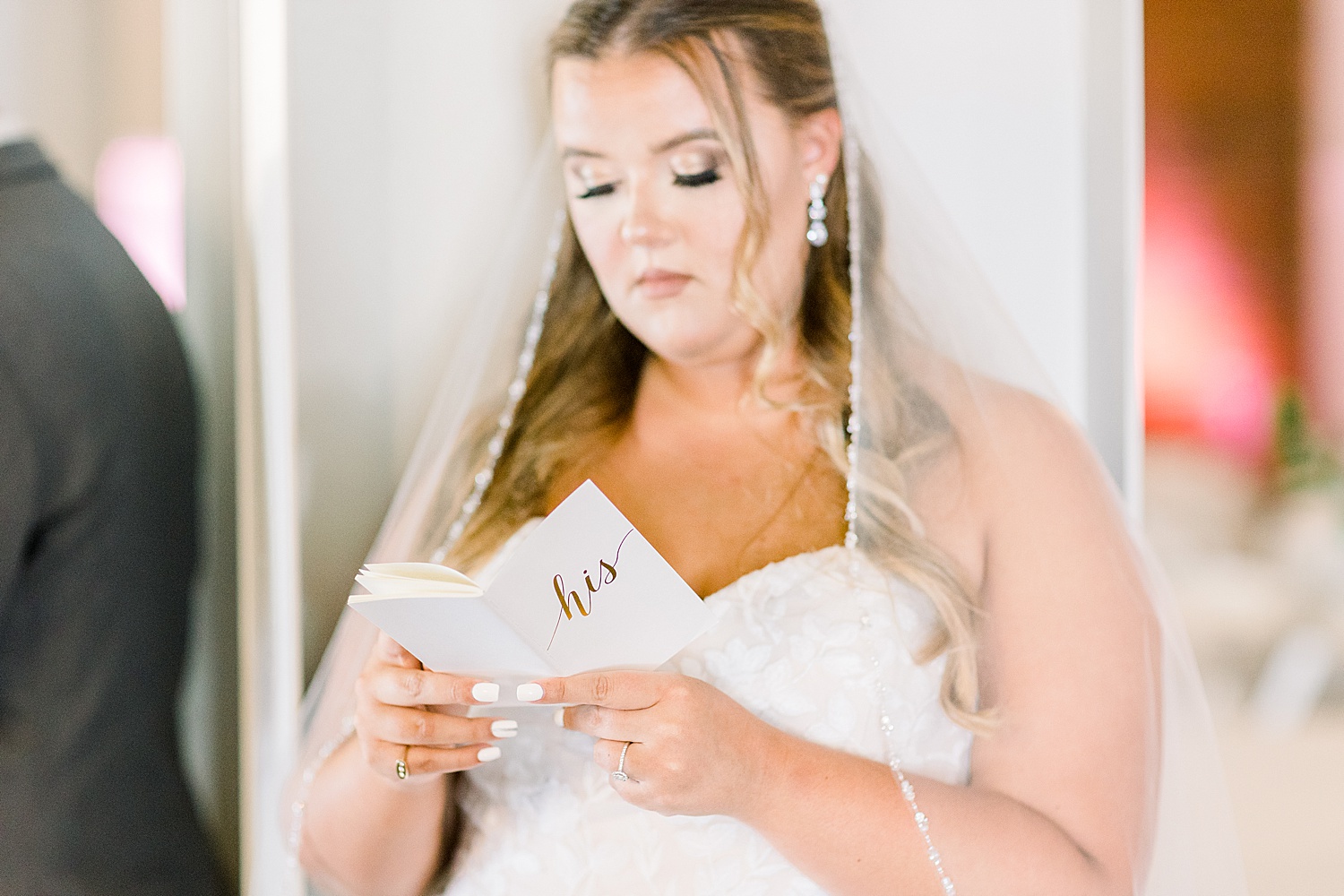 bride reads groom's vows during bride and groom have first touch in reception space