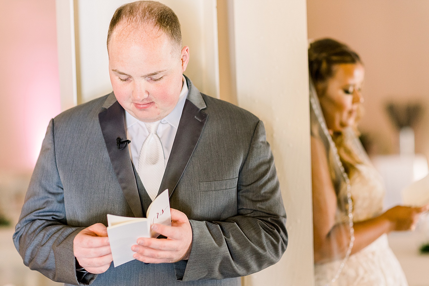 groom reads vows during bride and groom have first touch in reception space