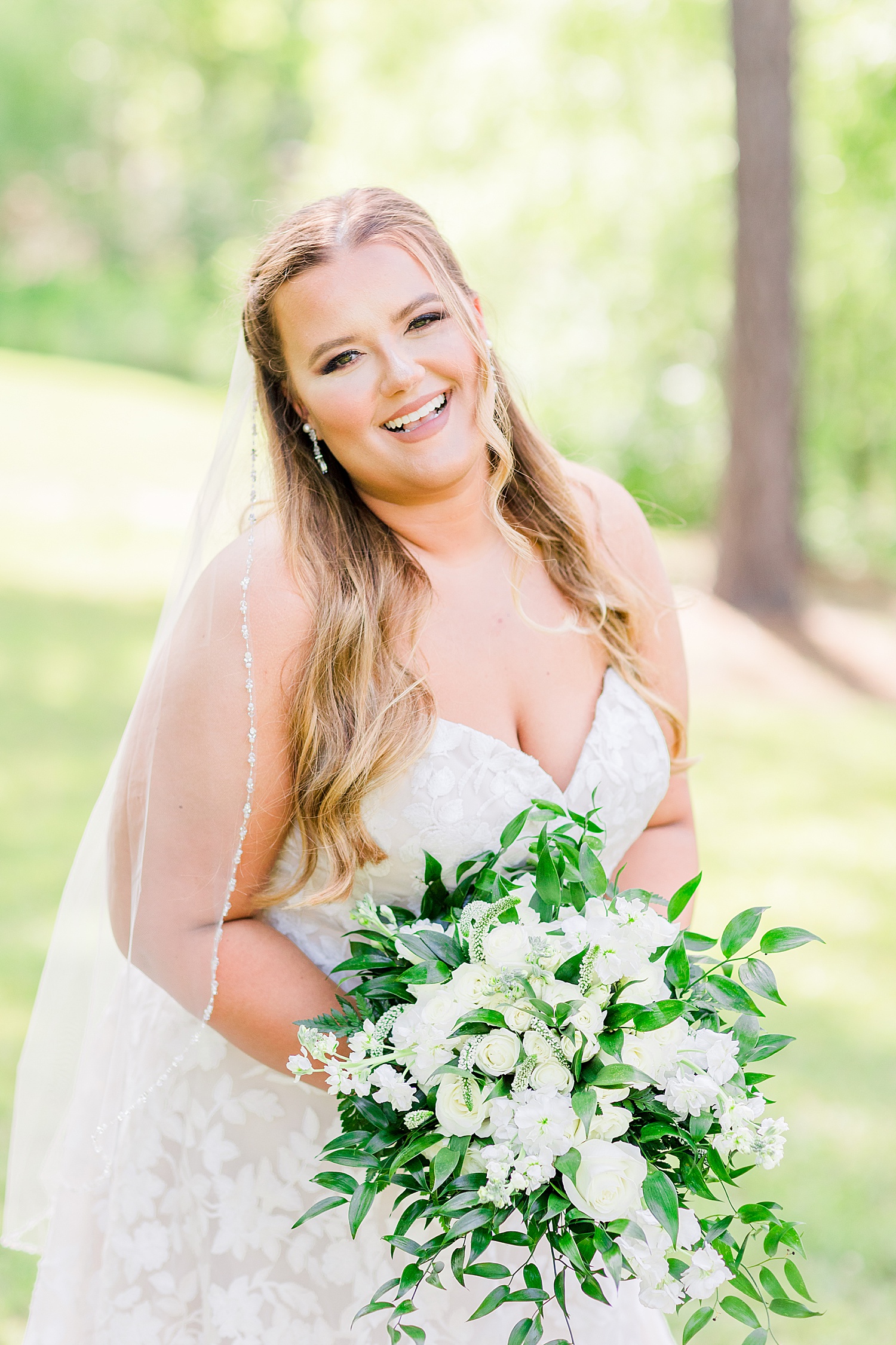 bride laughs during bridal portraits with white bouquet