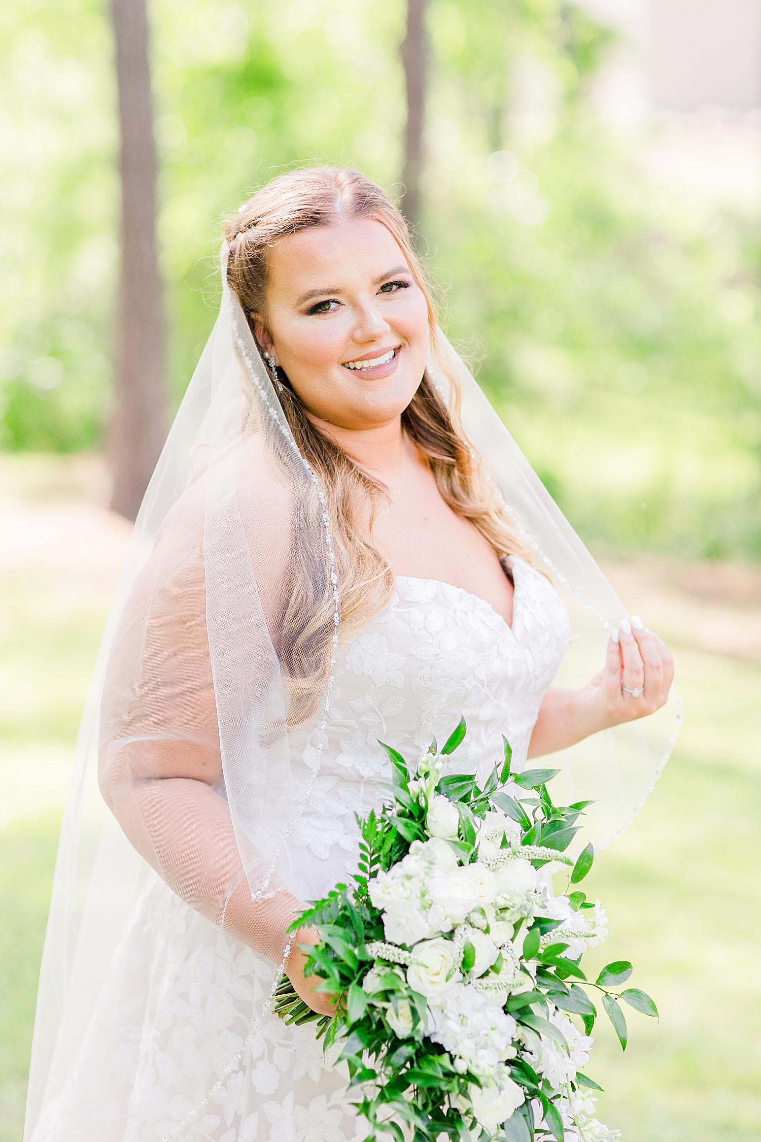 bride holds veil around shoulders