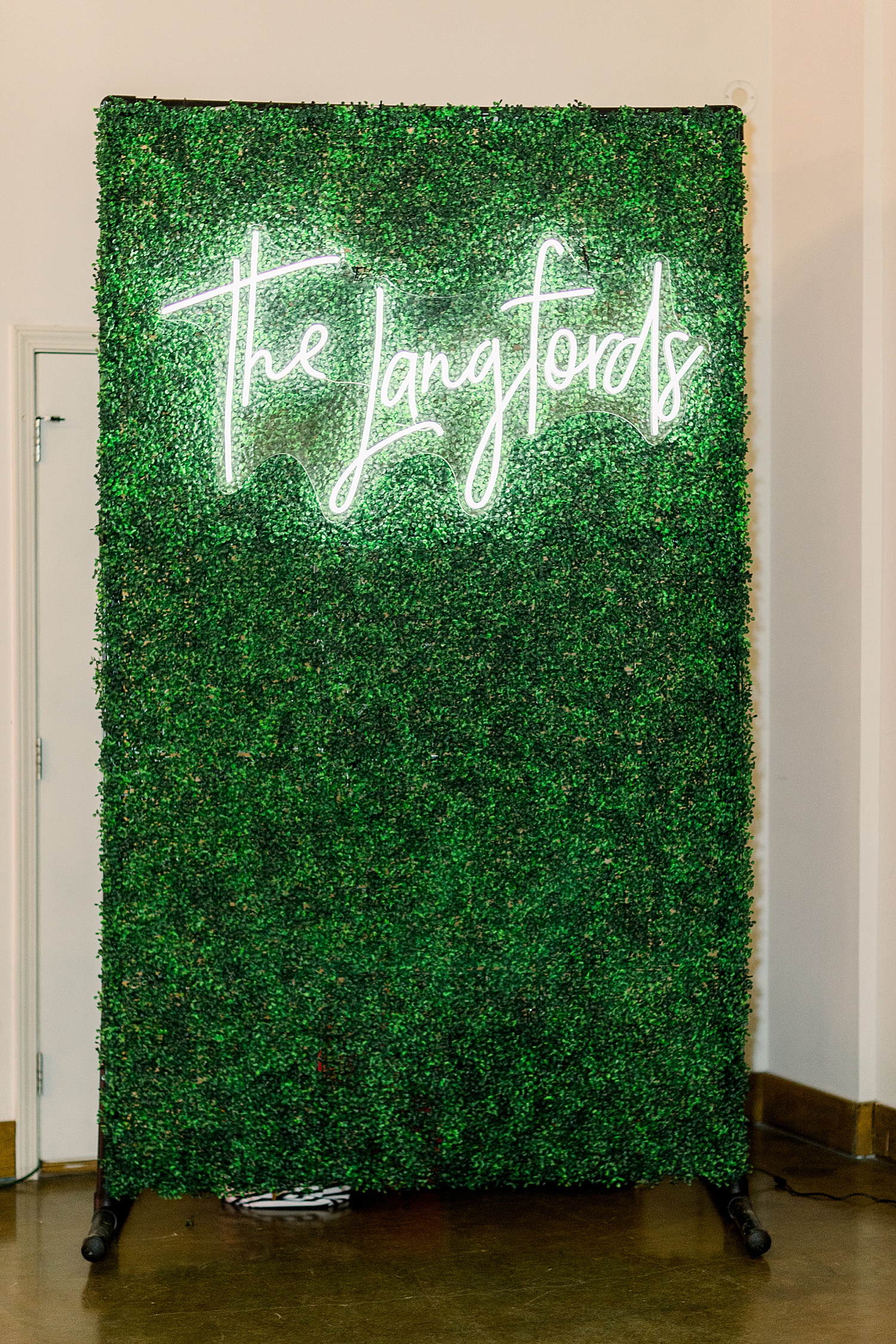 green wall with neon sign for Douglas Manor wedding reception
