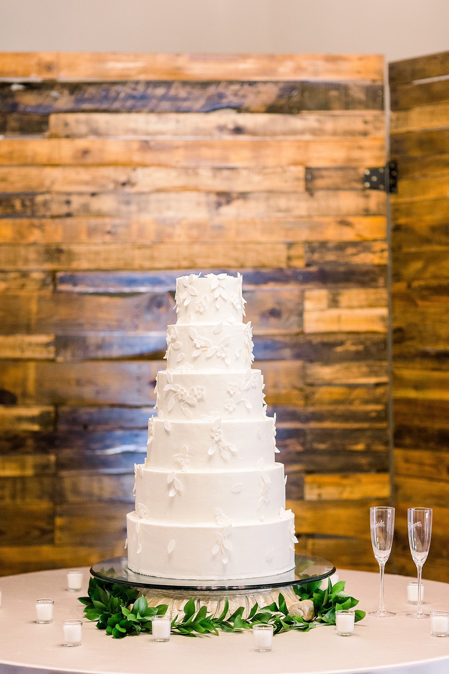tiered wedding cake by wood wall at Douglas Manor