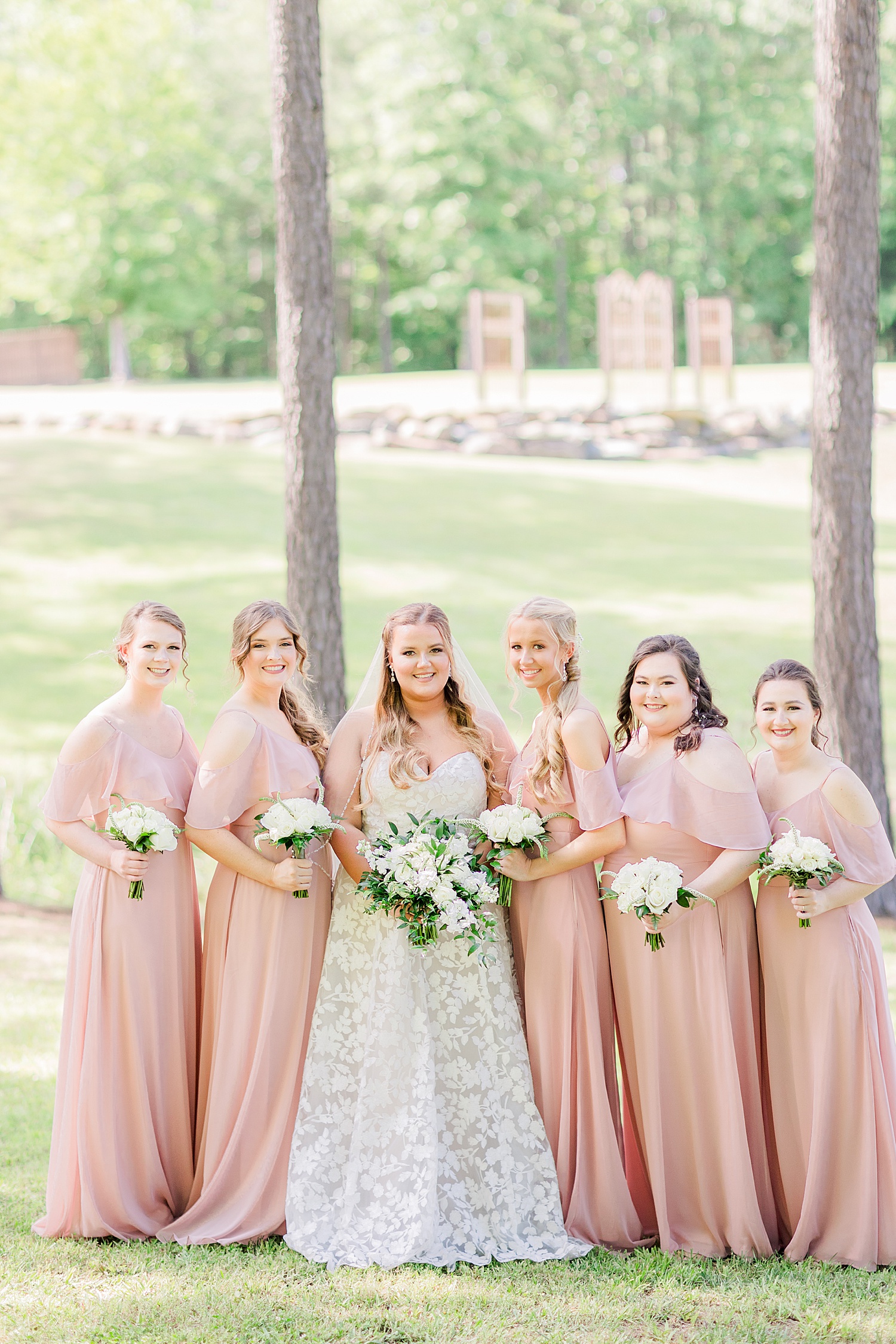 bride poses with bridesmaids in pink gowns at Douglas Manor