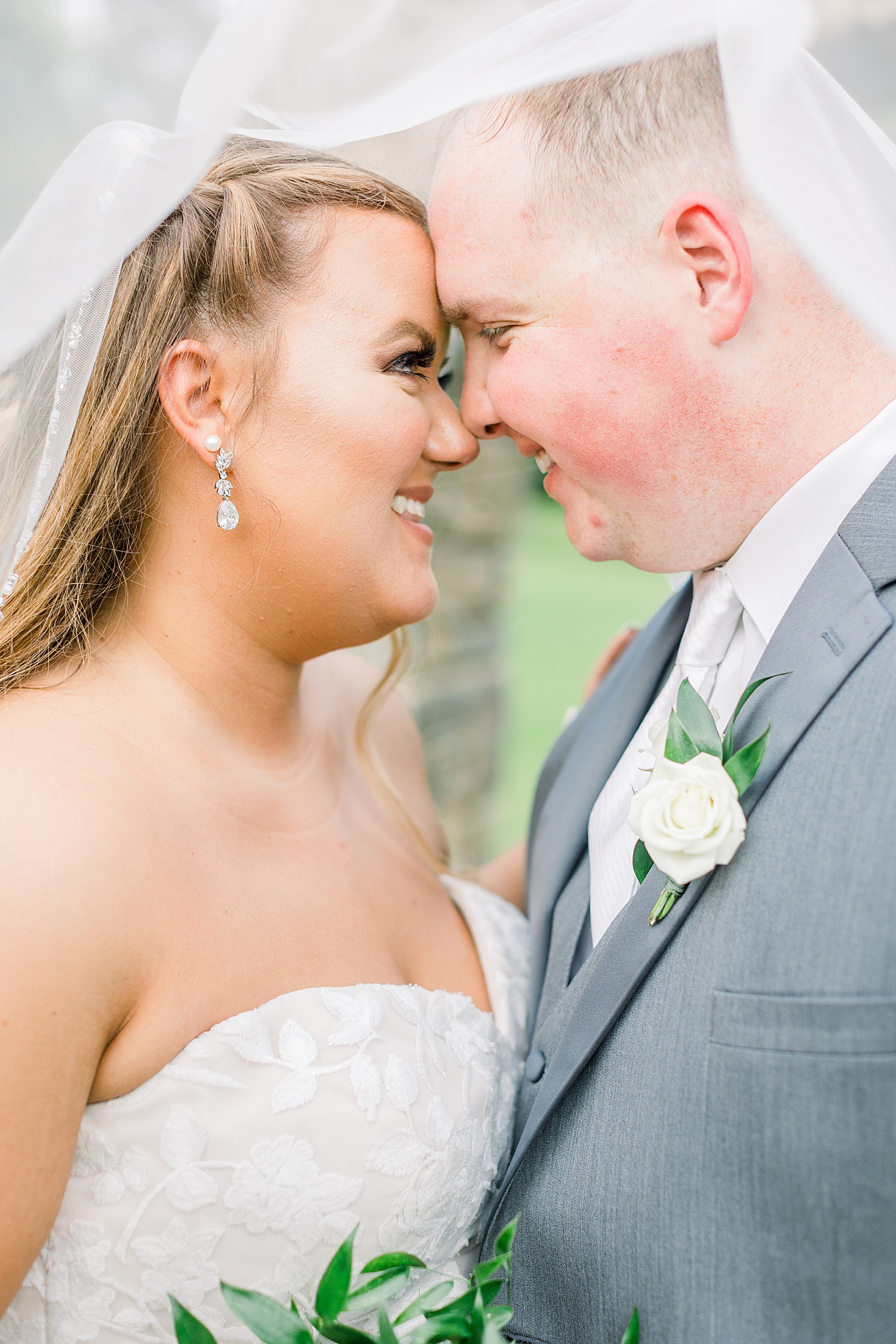 newlyweds stand with noses touching during wedding portraits at Douglas Manor
