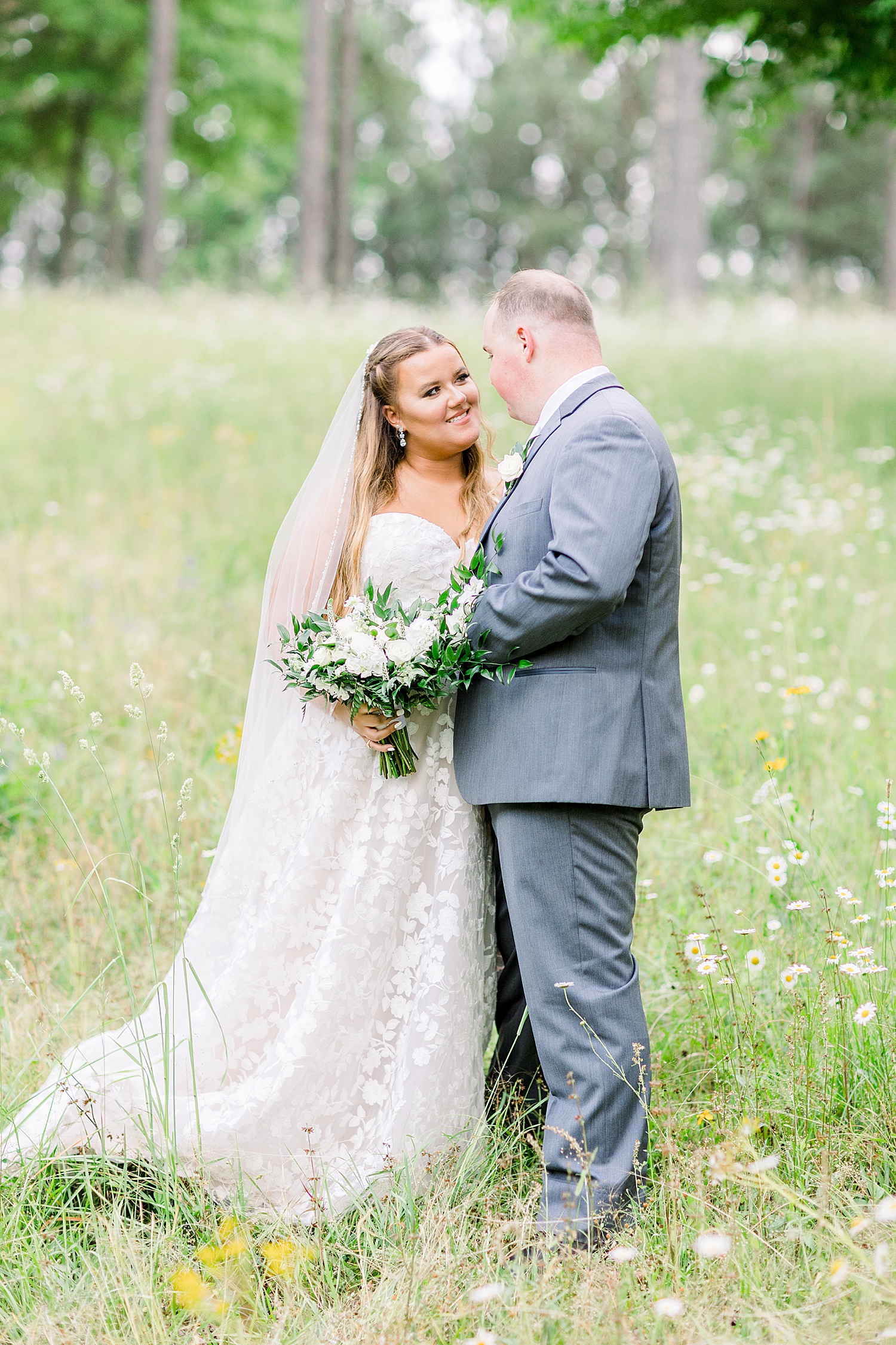 newlyweds pose toeter in field during AL wedding photos
