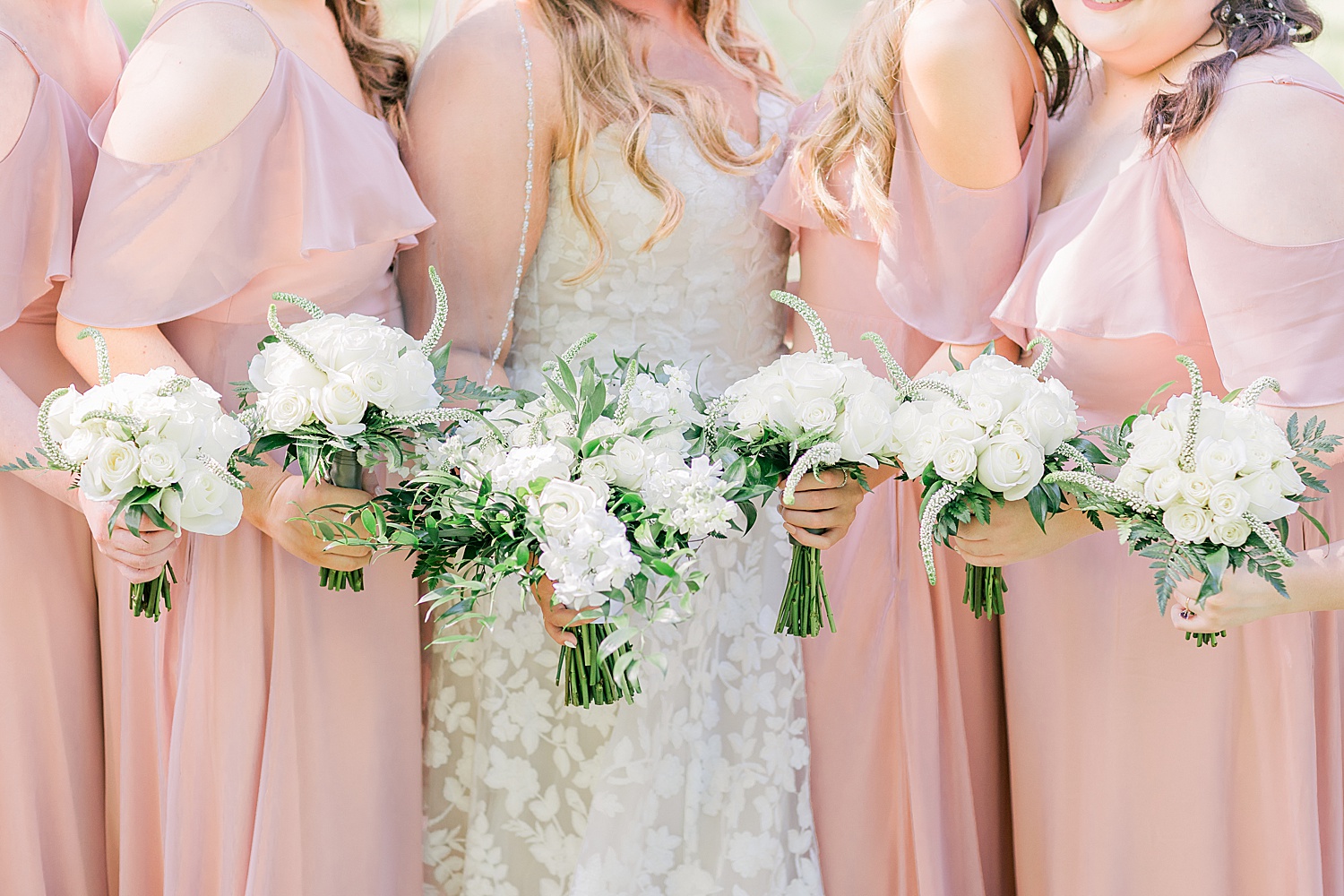 bride and bridesmaids hold ivory bouquets
