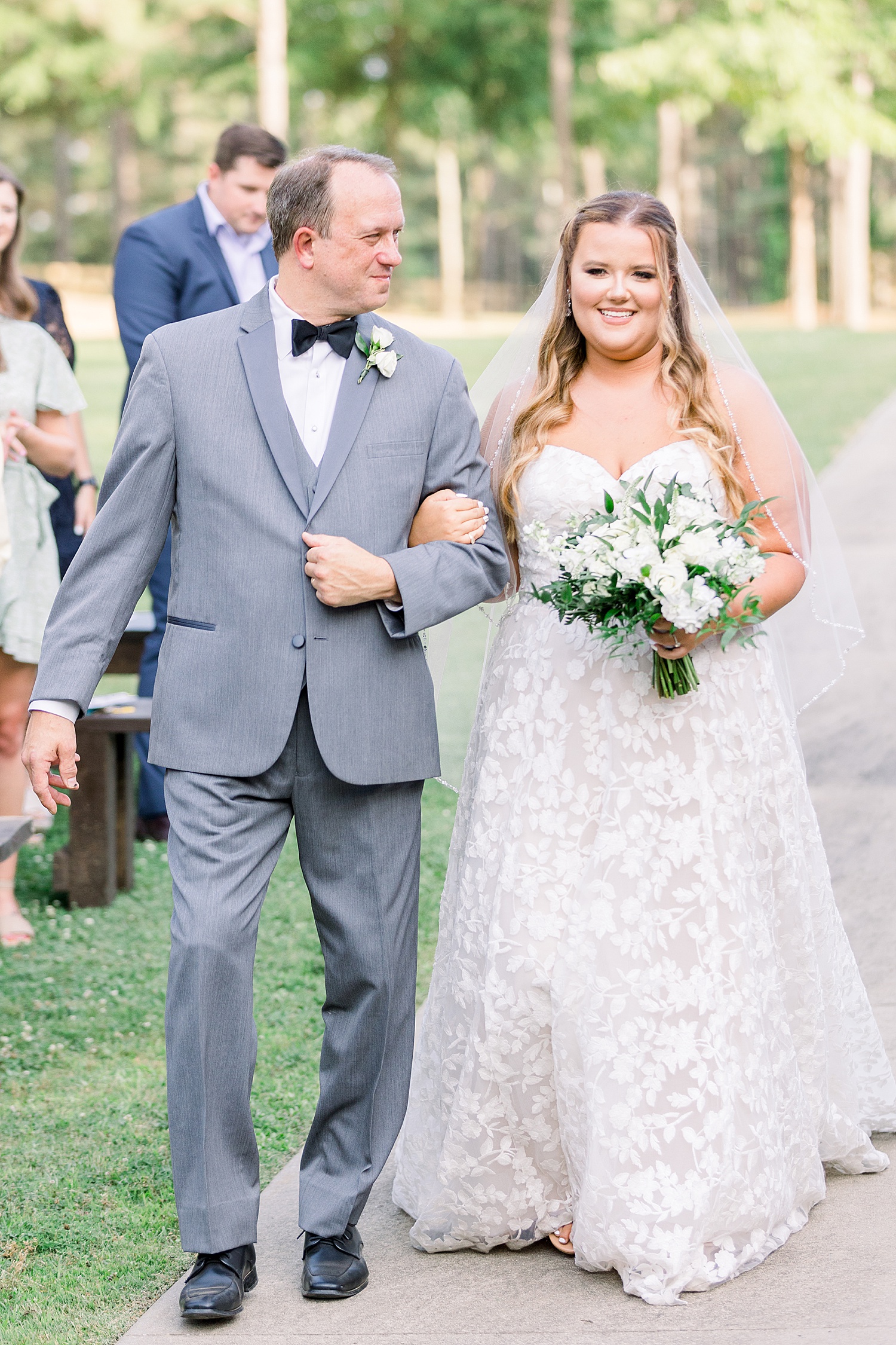 bride walks down aisle with dad during outdoor ceremony at Douglas Manor