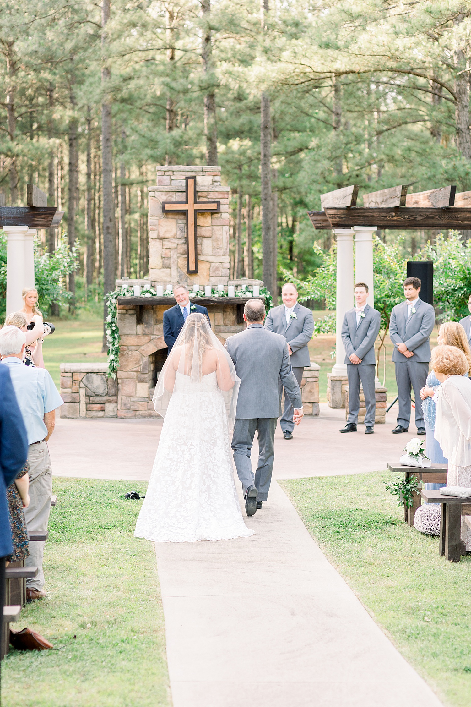 bride walks down aisle with dad during outdoor ceremony at Douglas Manor
