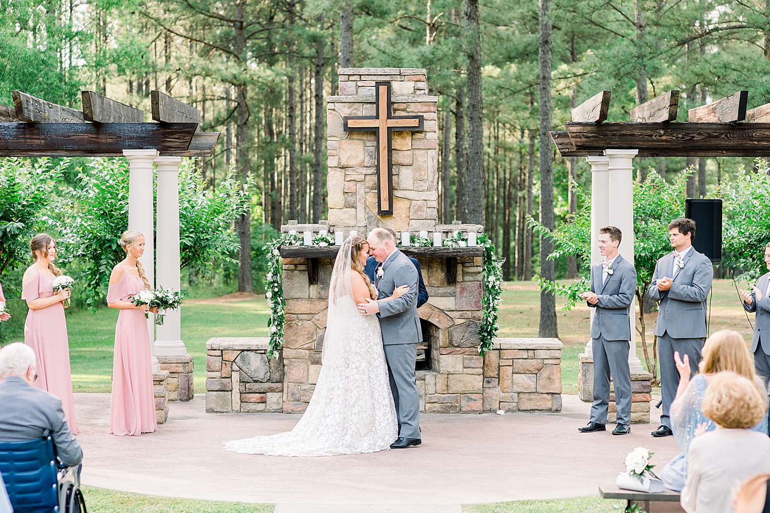 newlyweds touch heads during outdoor ceremony at Douglas Manor
