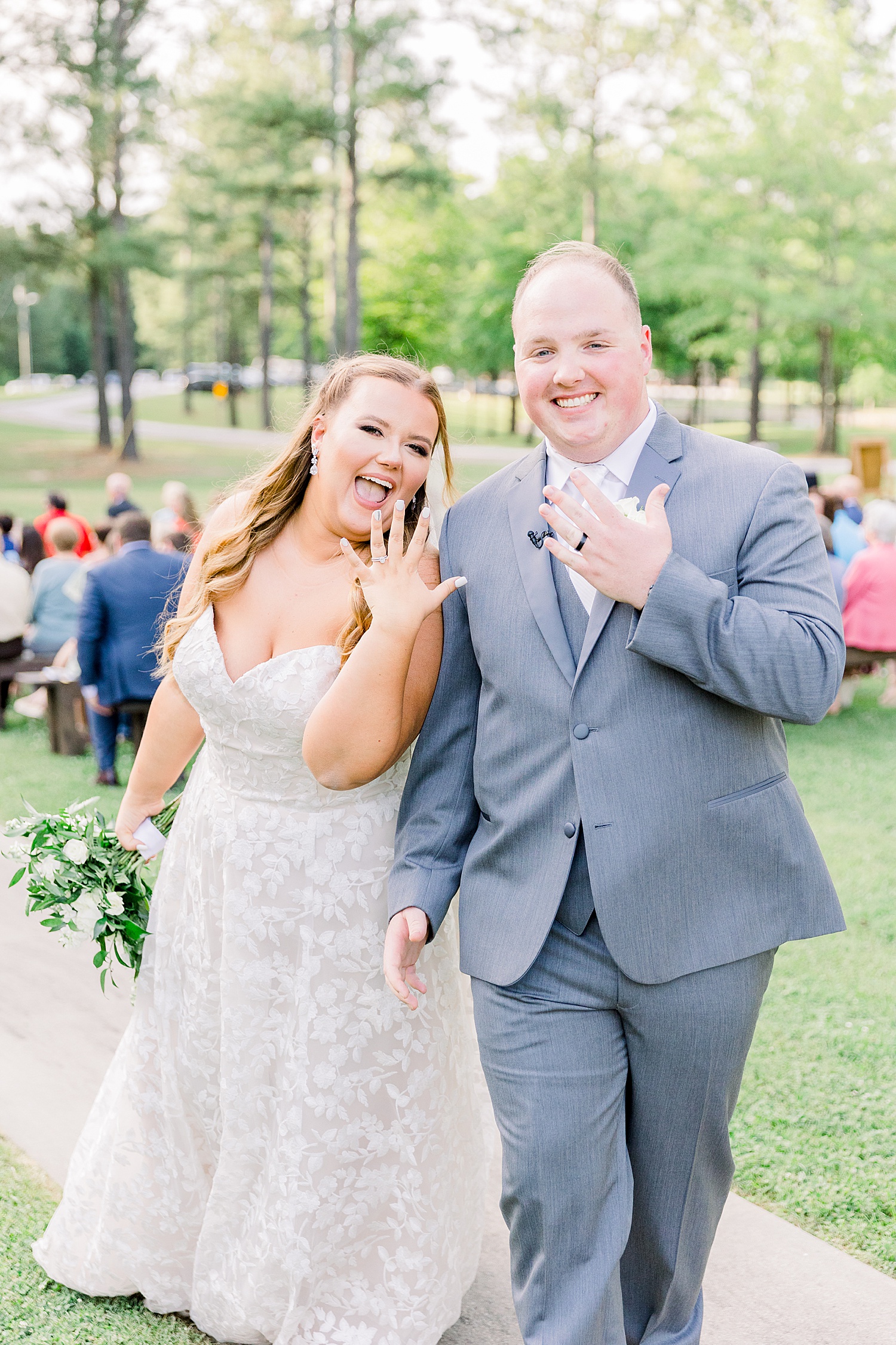 couple shows off rings during outdoor ceremony at Douglas Manor