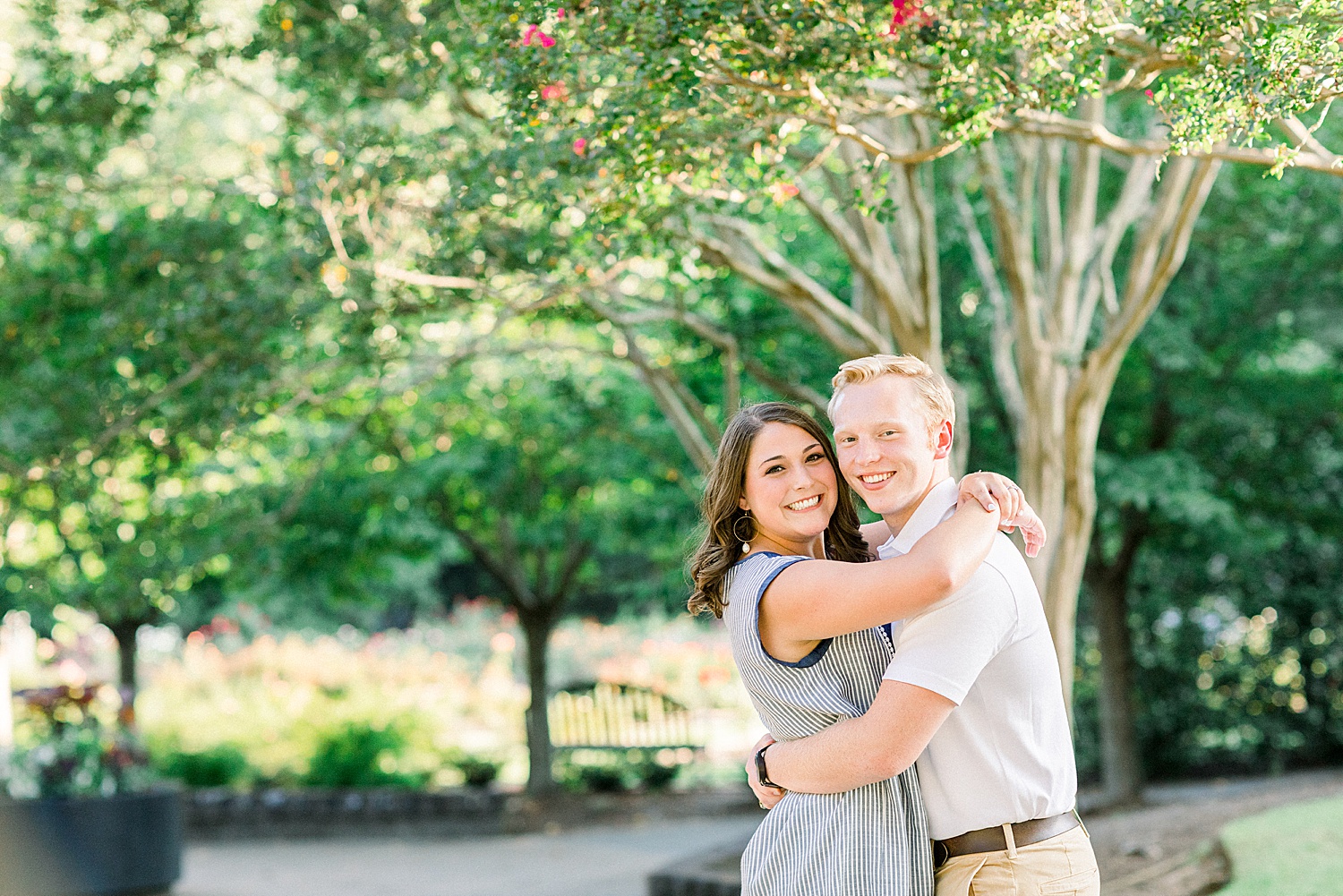 bride and groom hug by tree during Downtown Birmingham engagement session