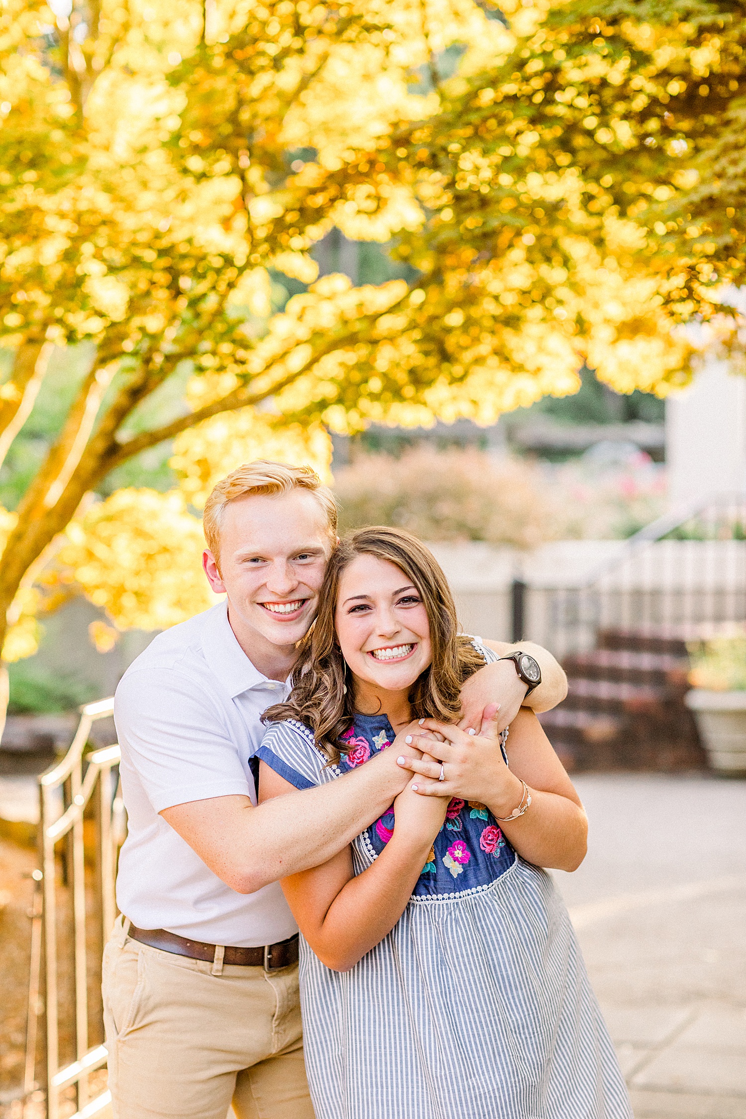 couple hugs by yellow tree during Downtown Birmingham engagement session