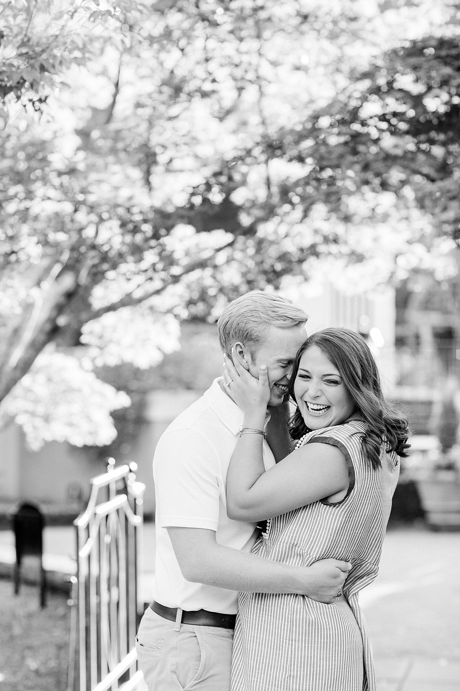 groom nuzzles bride's cheek during engagement photos in Railroad Park