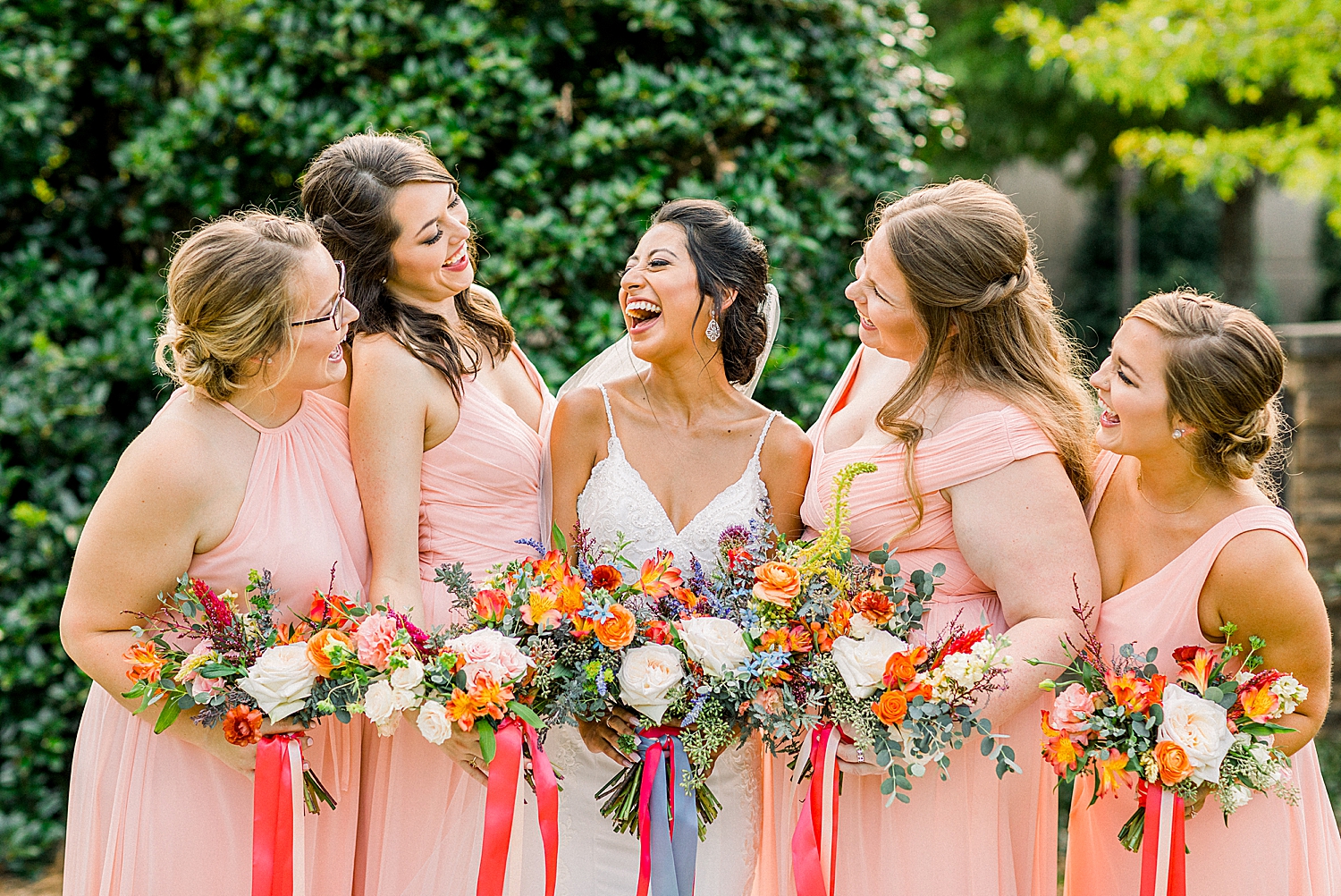 bride laughs with bridesmaids during AL wedding photos