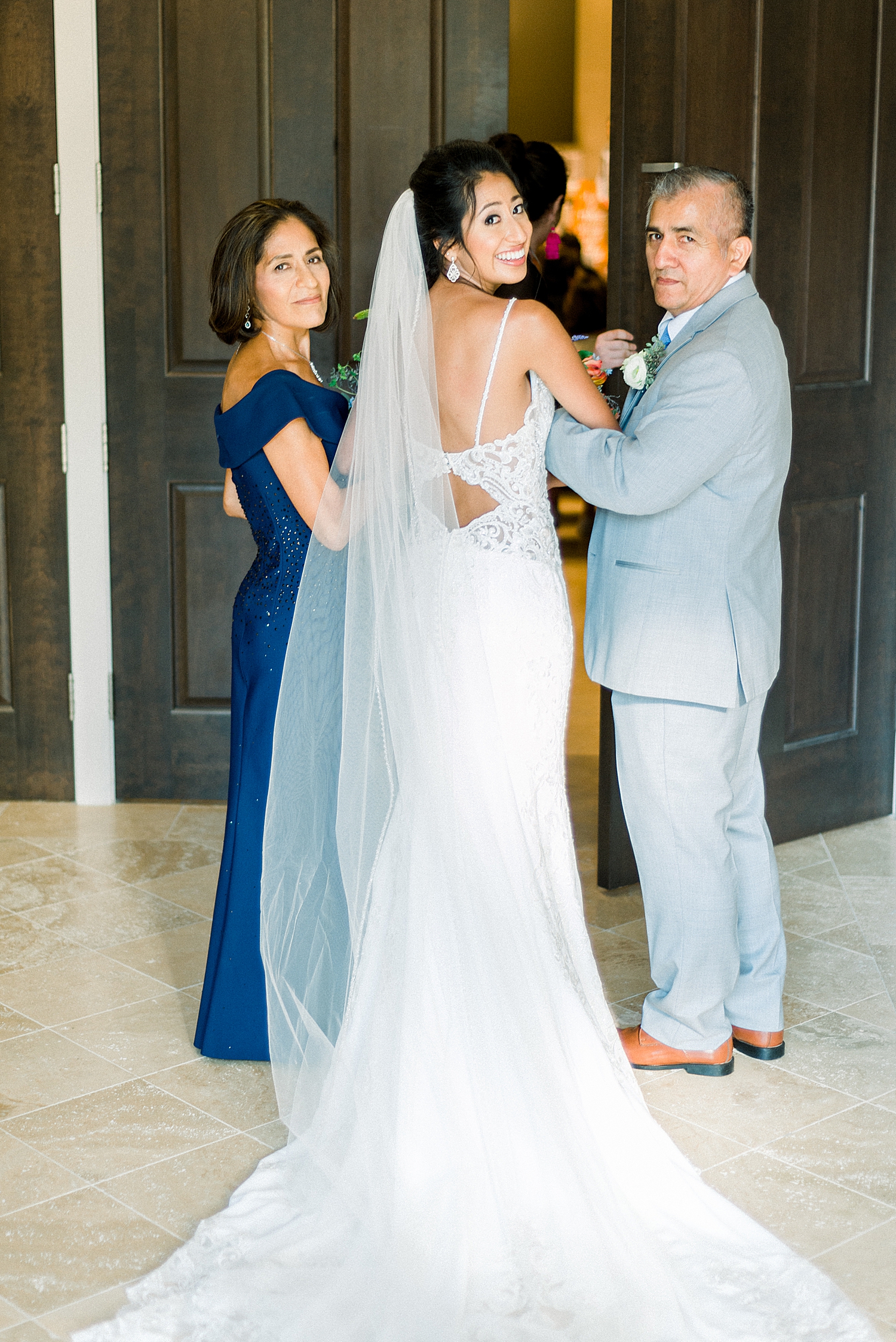 bride looks back with parents before AL ceremony
