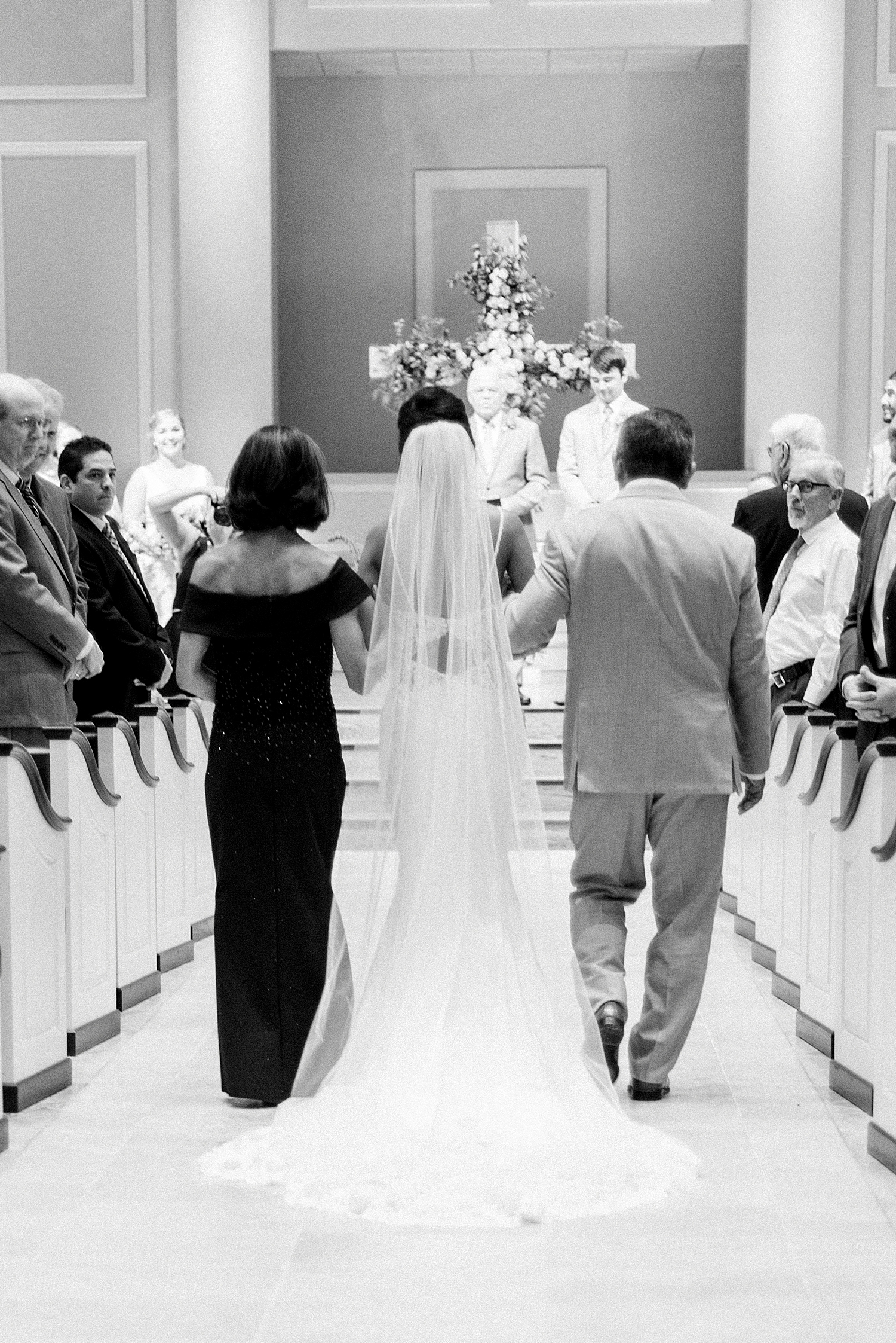 bride walks down aisle with parents during AL wedding ceremony