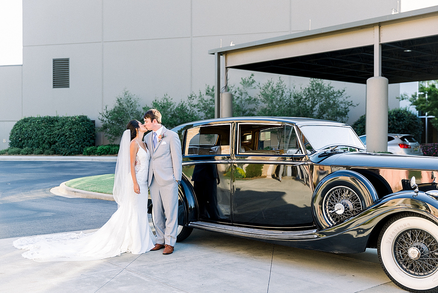 bride and groom pose with vintage cars