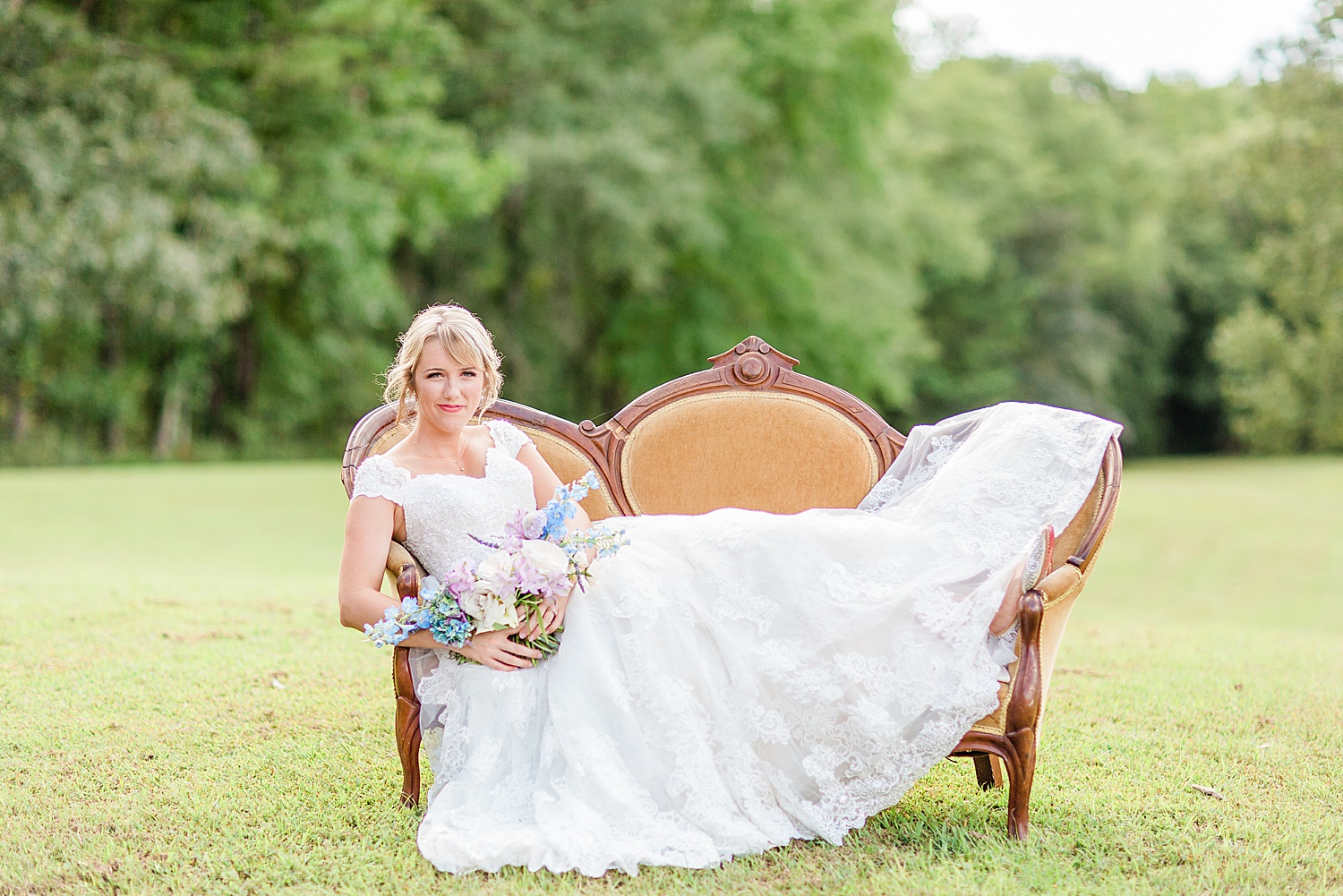 Bride holding wedding bouquet laying on bench before wedding in Alabama