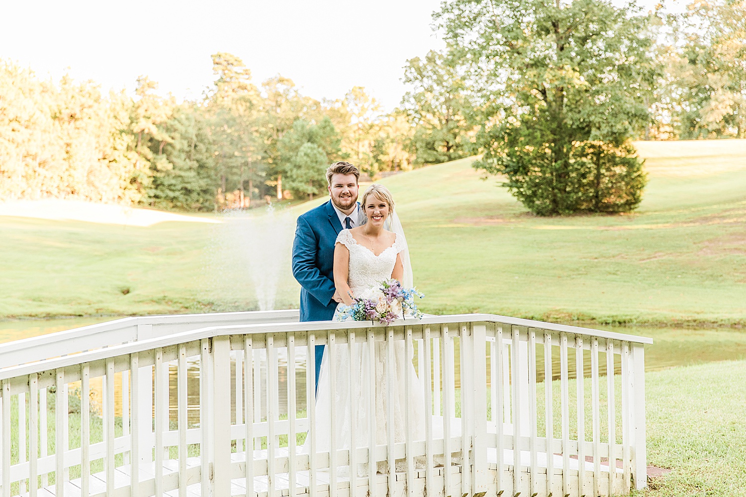 husband and wife stand on footbridge at Applewood farms in Pell city AL