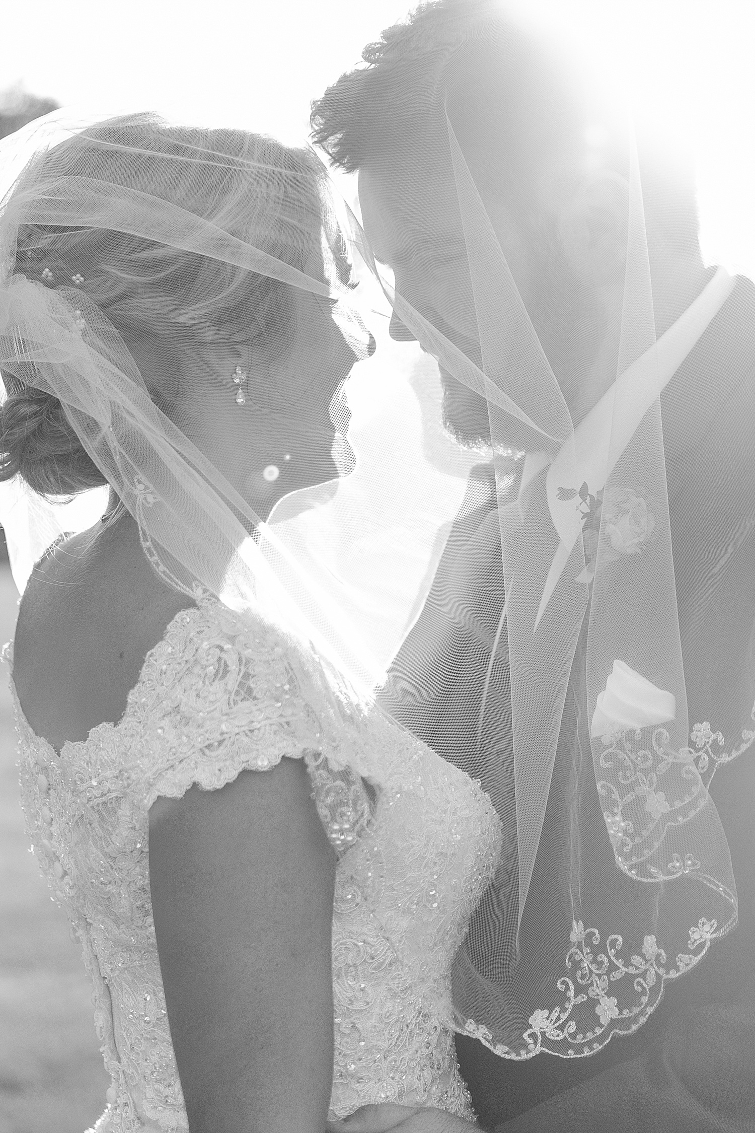 newlyweds kiss under brides veil