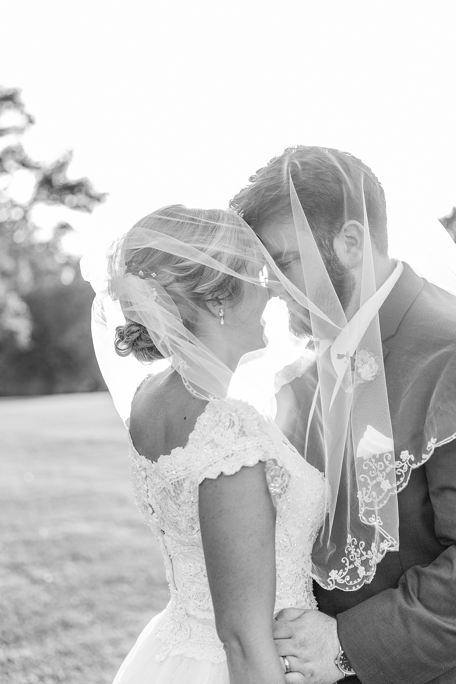 newlyweds kiss under brides veil