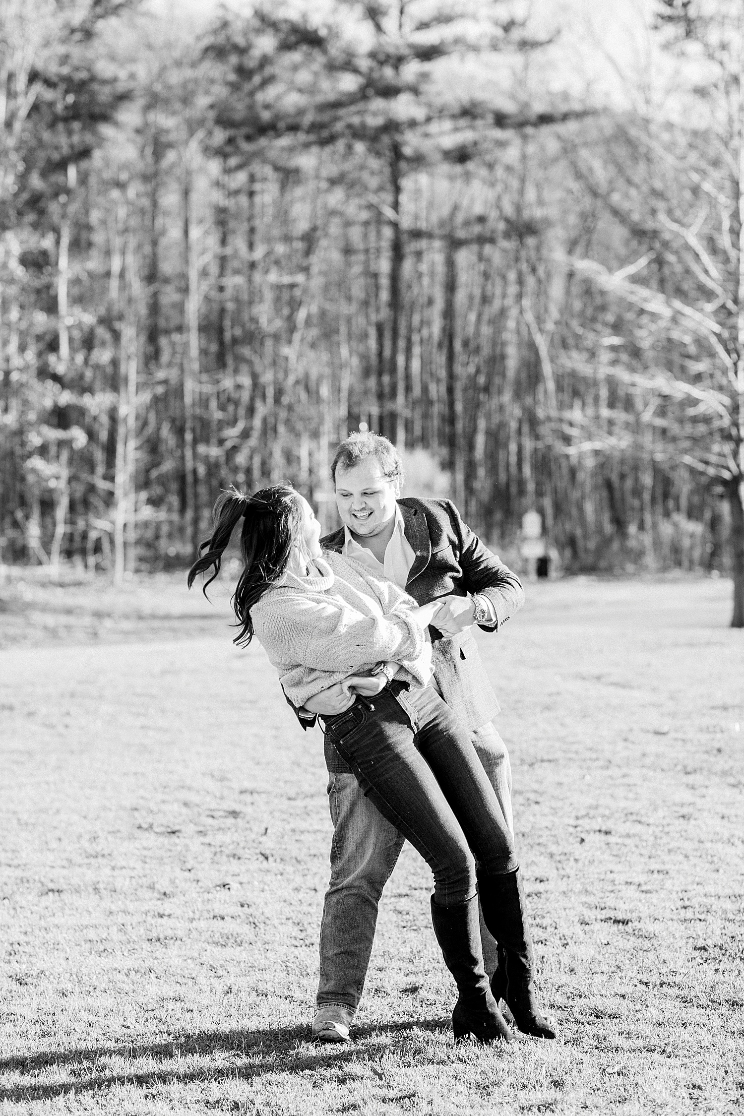 couple dances in the grass field during engagement session