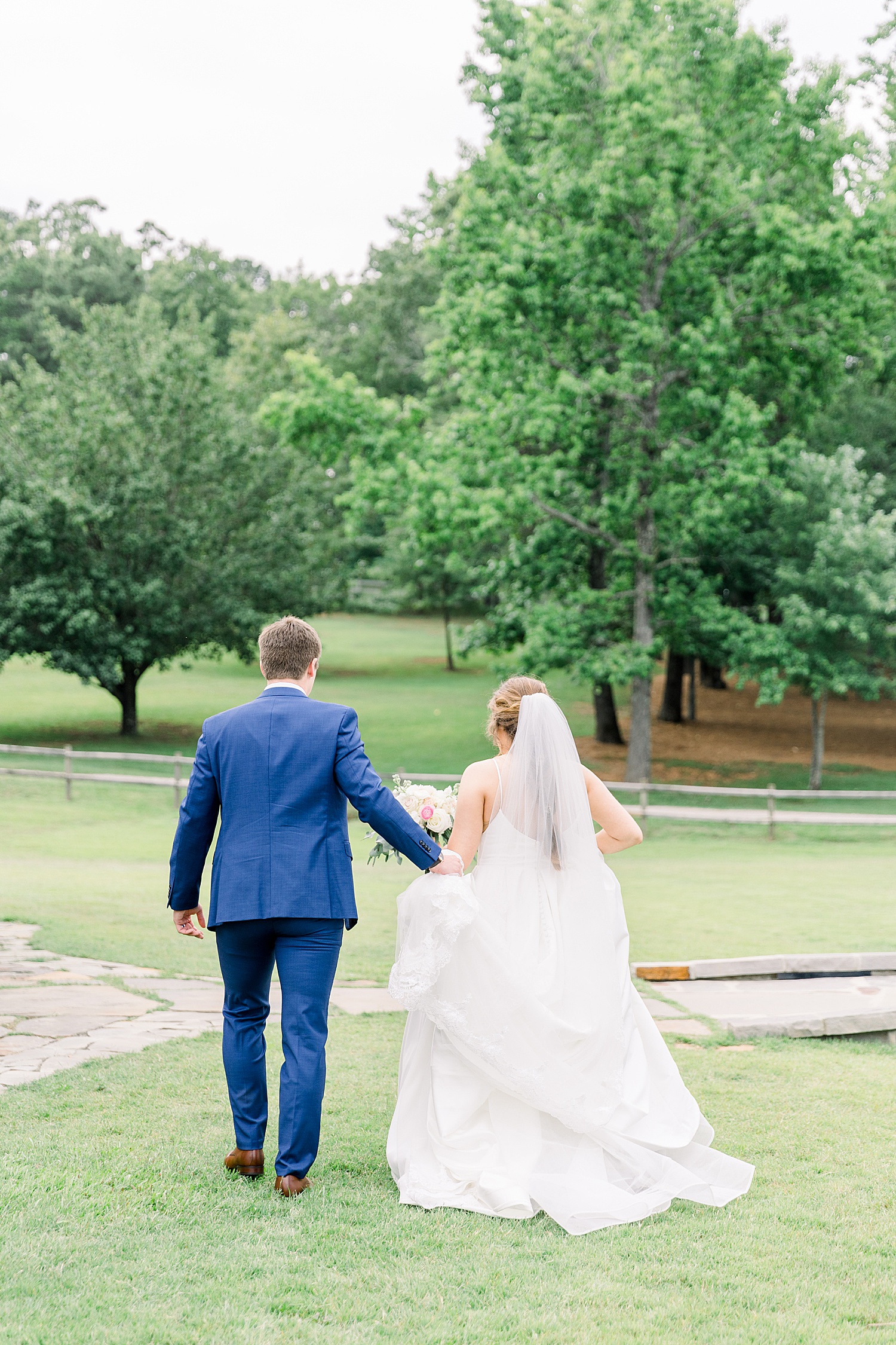 Bride + groom walk holding hands as husband and wife captured by Chelsea Morton Photography
