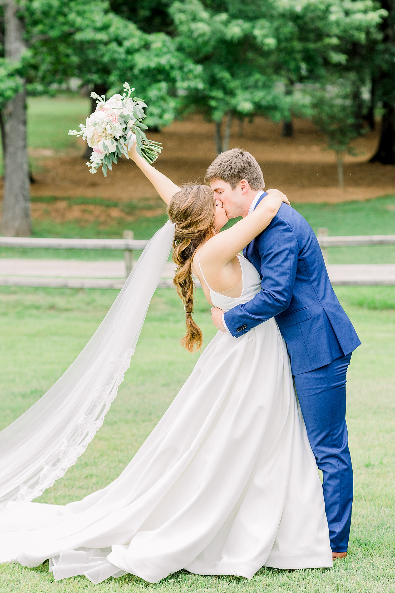 Husband kisses his new bride on the grounds of The Barn at Shady Lane in Birmingham AL