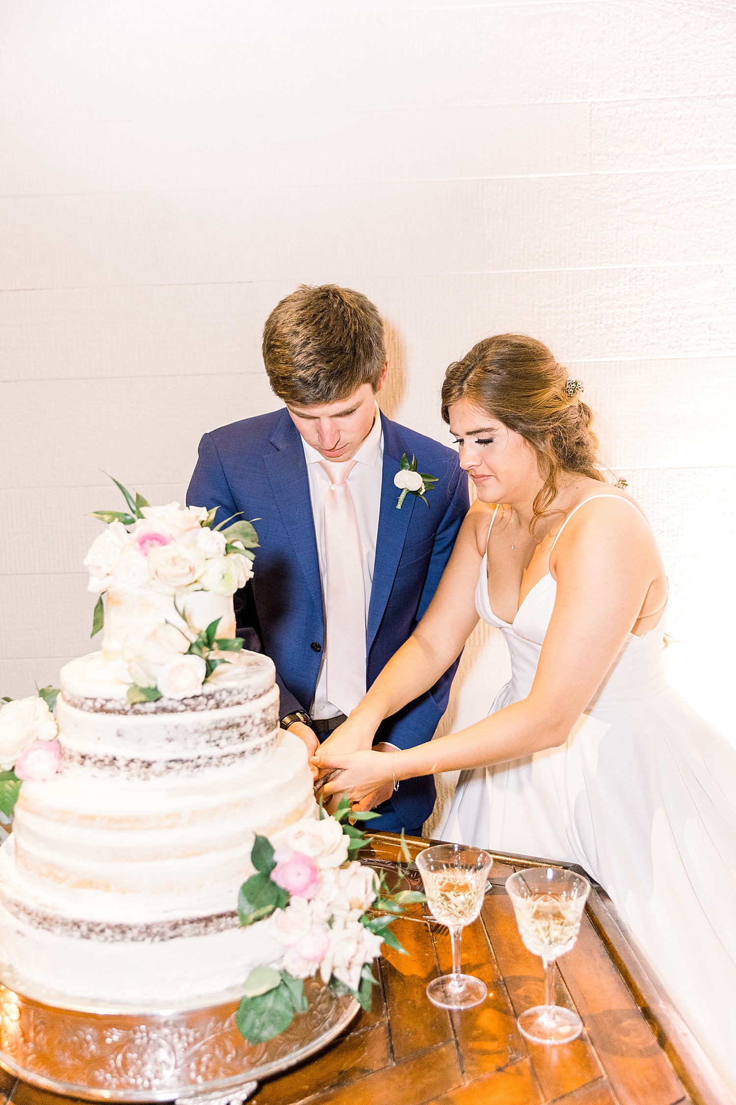 bride + groom cut wedding cake during Birmingham wedding