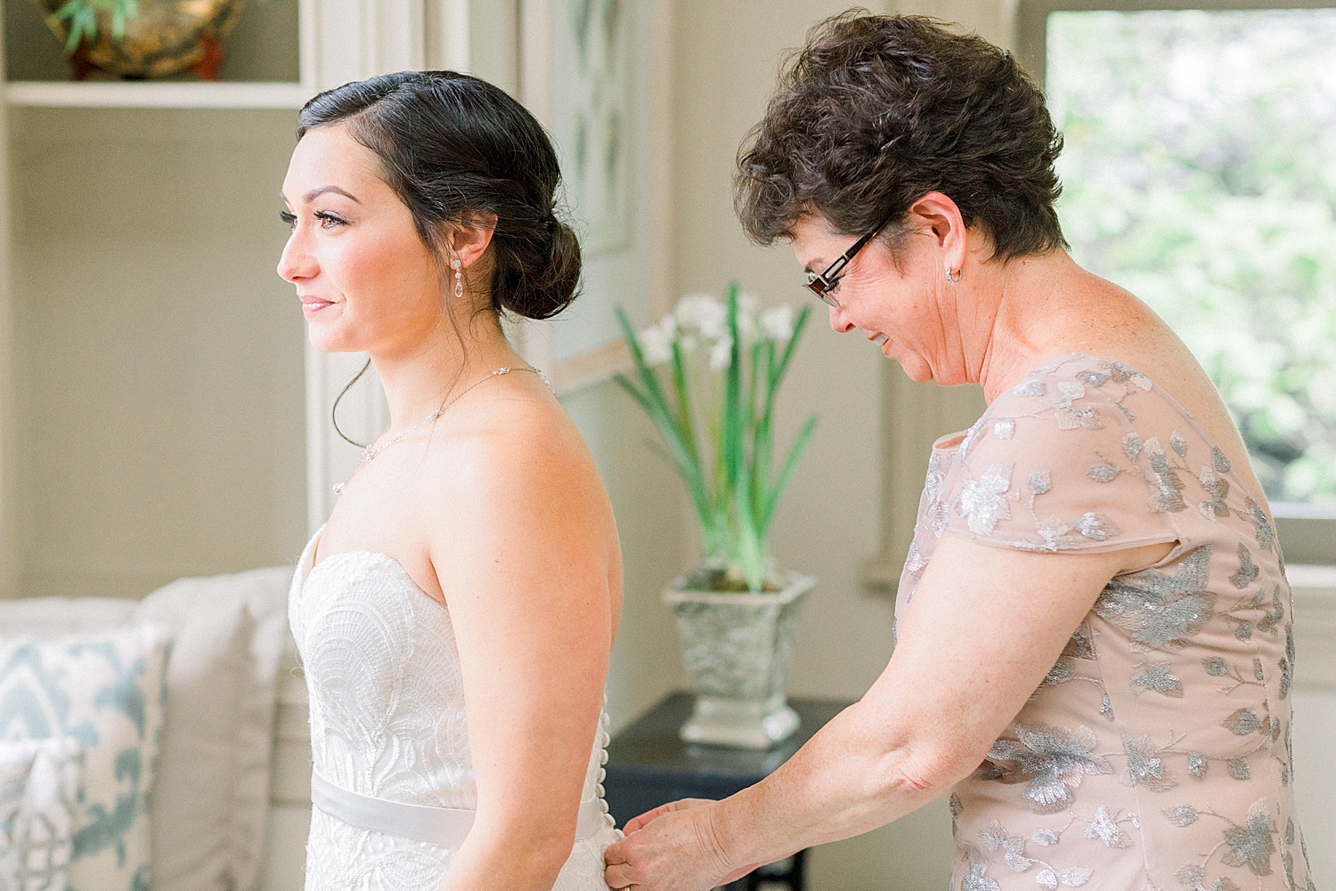 mom helping bride with wedding dress captured by Chelsea Morton Photography