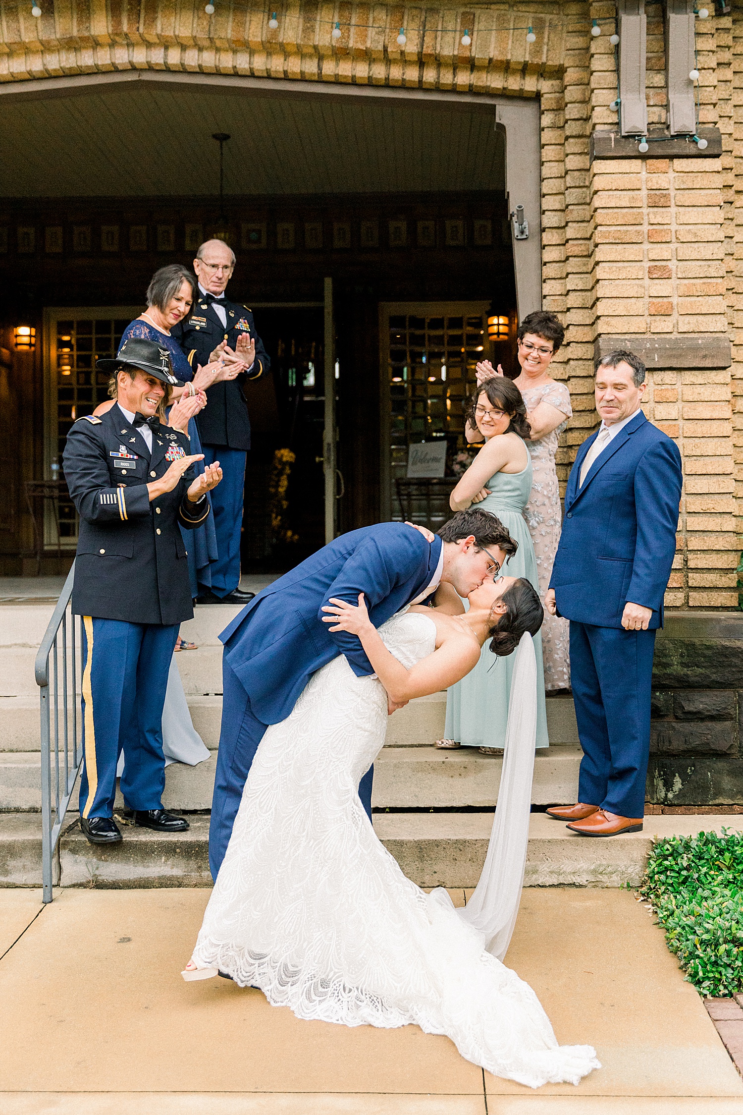 newlyweds kiss at the bottom of stairs outside venue by Chelsea Morton Photography
