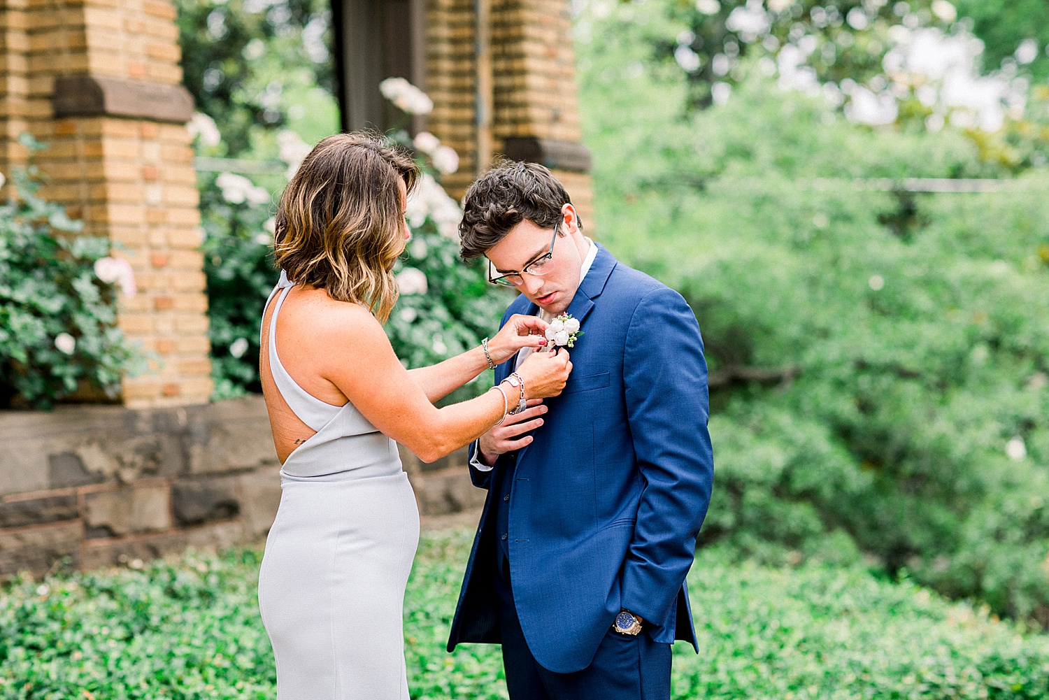mother of the groom helps son get ready