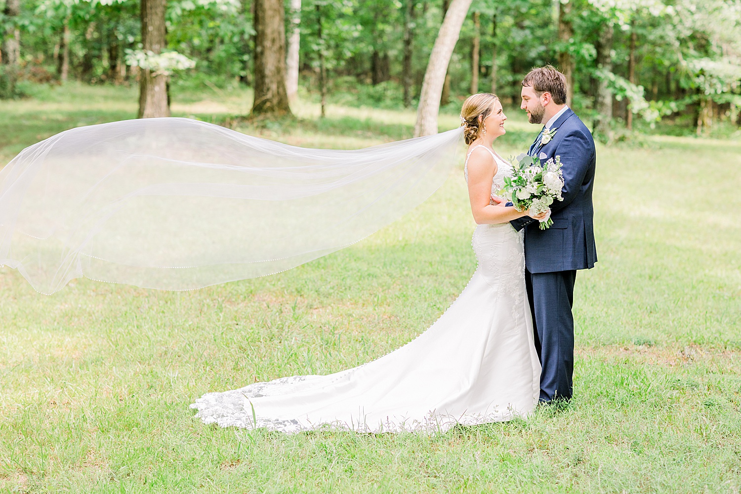 bride + Groom in open field with bride's veil floating in the wind of Belle Farms in Sterrett Alabama